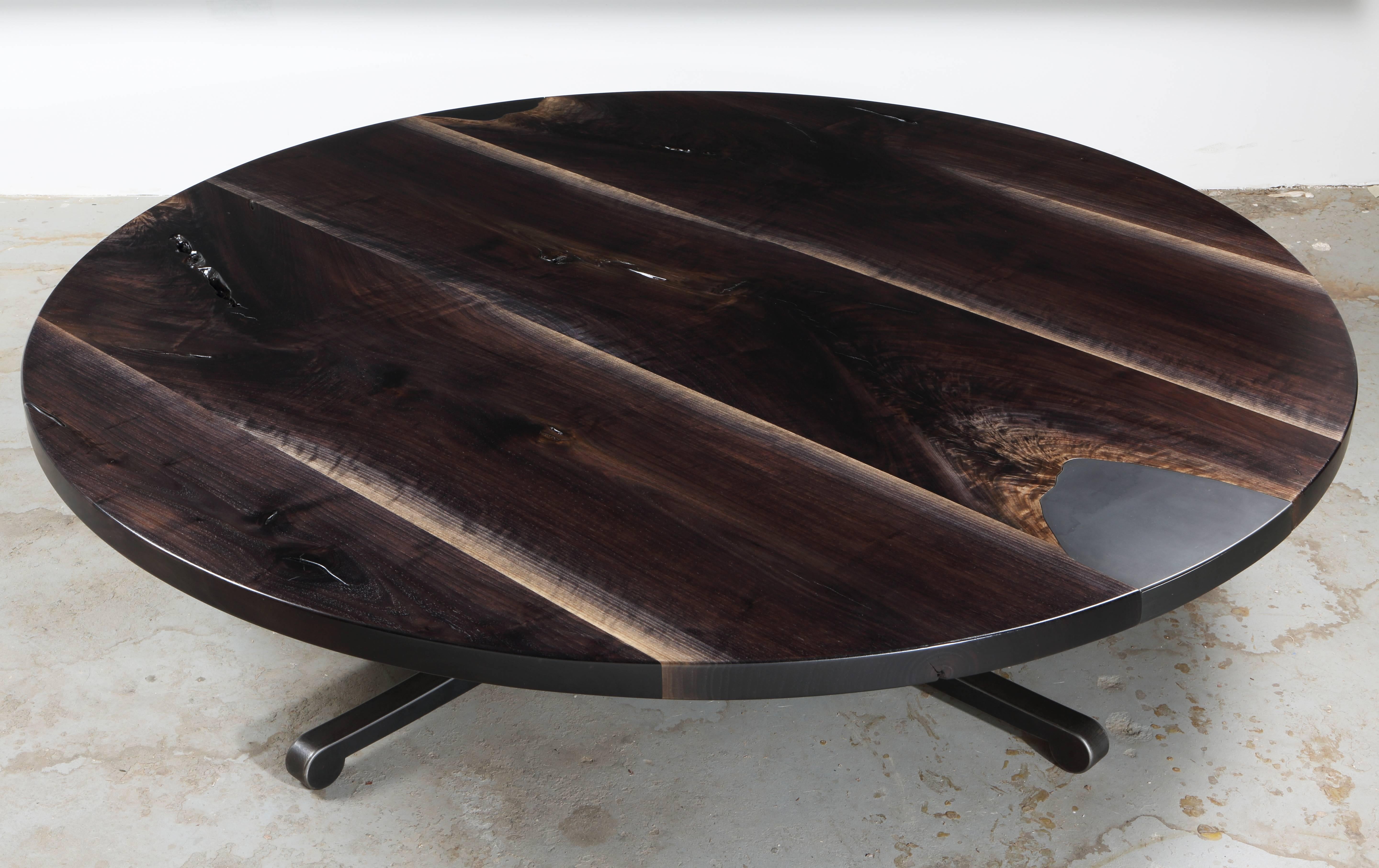 Alternating grain patterns of oxidized figure walnut lend a celestial effect to the top of the Serif coffee table. Grain matched steel inlays, with removable steel plate revealing hidden storage. Signature Serif leg, shown in raw flame cut finish.