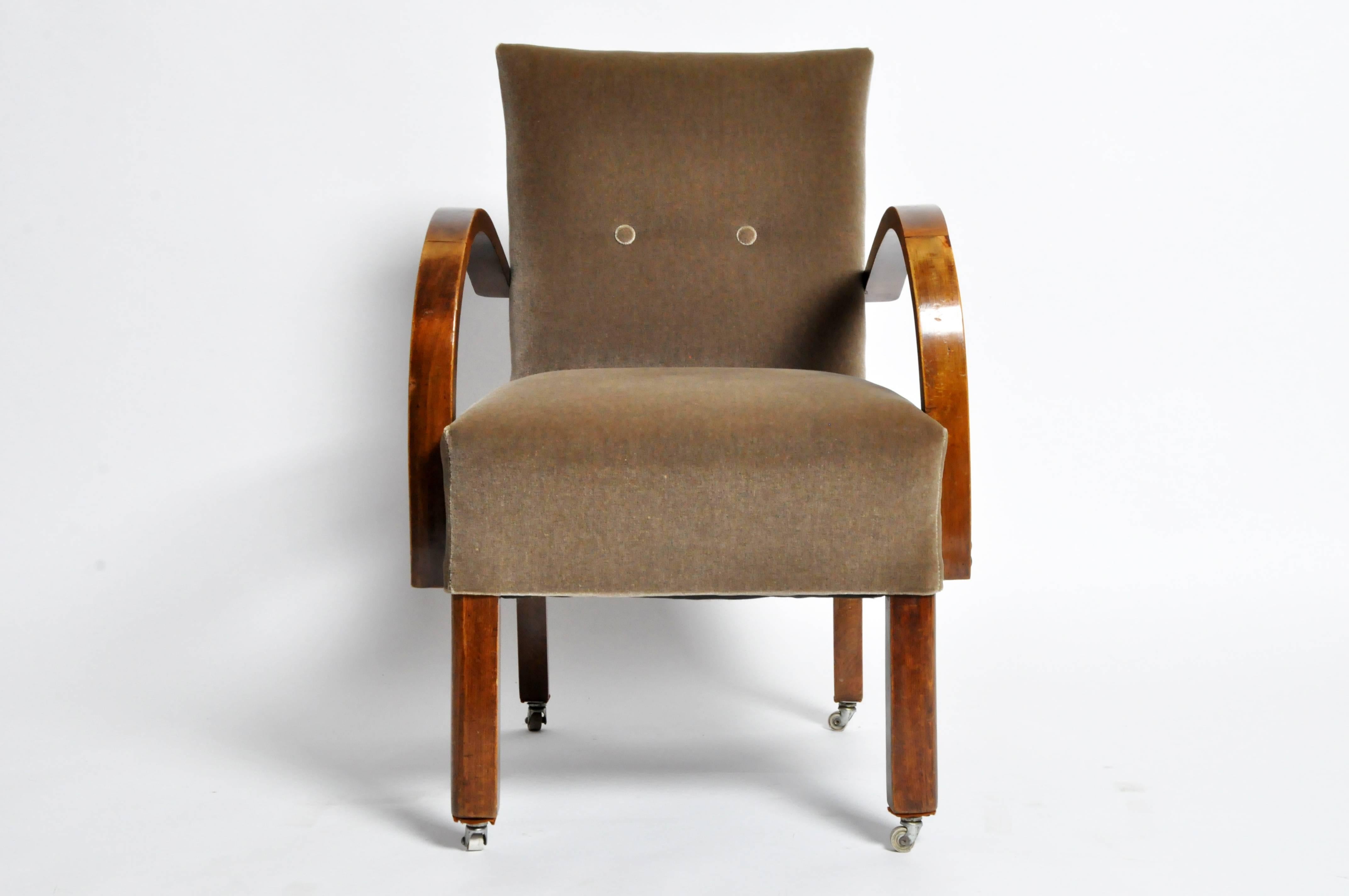This handsome Art Deco style open armchairs is from Budapest, Hungary and is made from solid walnut. The chair features casters on the legs as well.