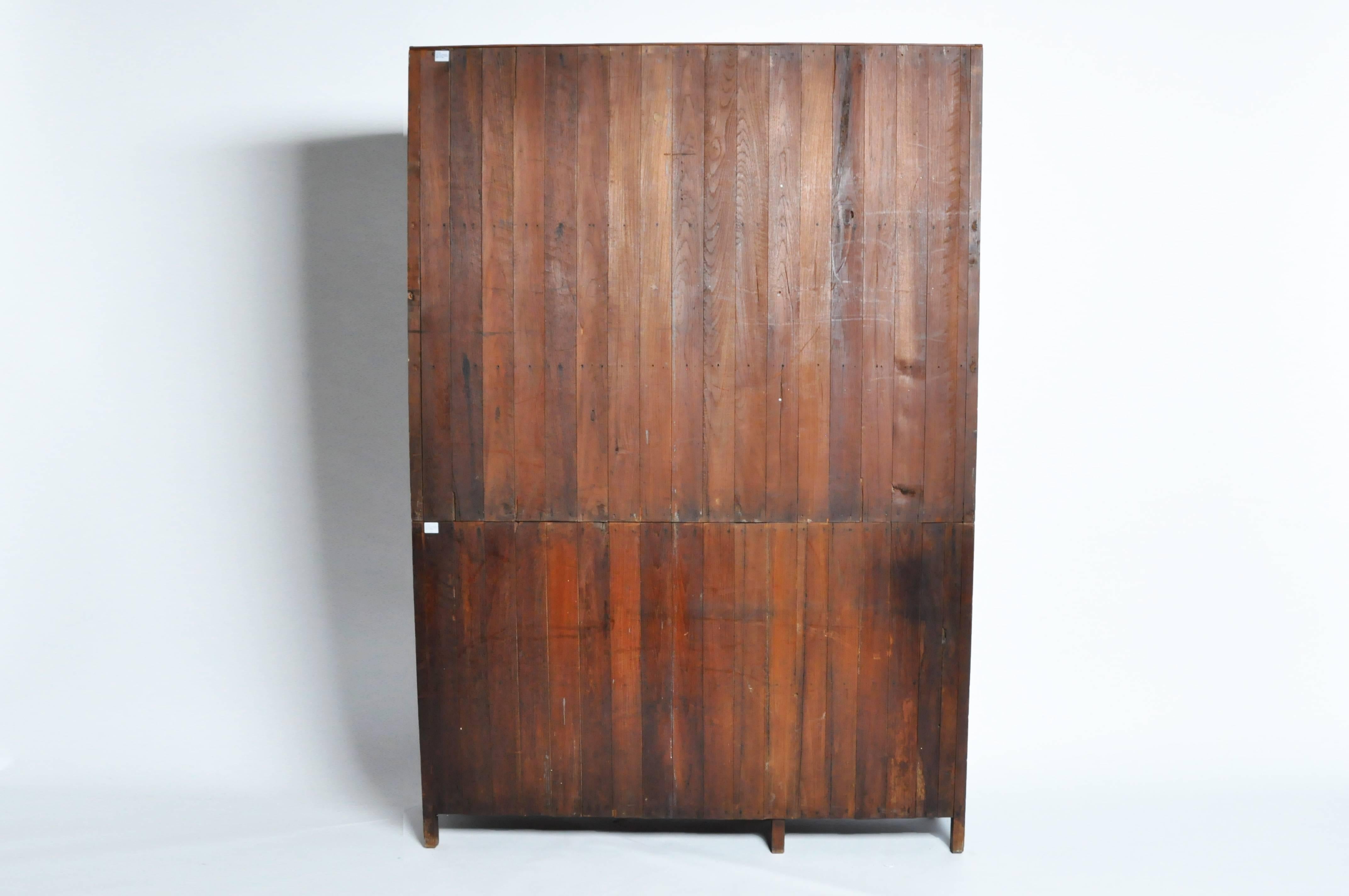 This handsome British Colonial bookcase is from Mandalay, Burma and is made from teak wood. It comes in two parts and features three sections of glazed doors that open to compartments lined with shelves. Perfect for use as a hutch to display