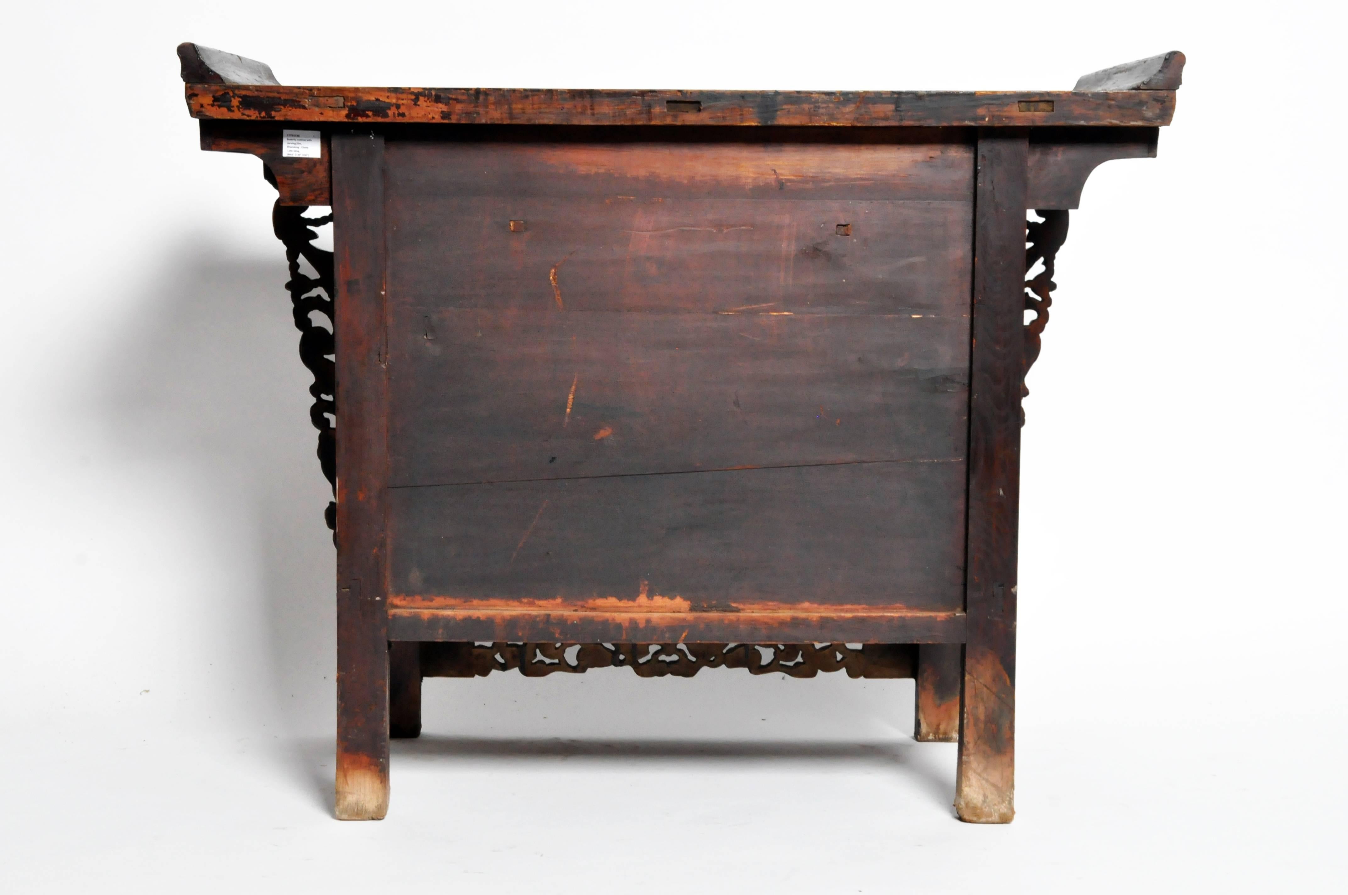 This handsome chest is from Shandong, China and made from elmwood circa late Qing dynasty. The piece features one drawers, a sliding door that exposes a compartment for additional storage, intricate hard-carved details, and original patina.