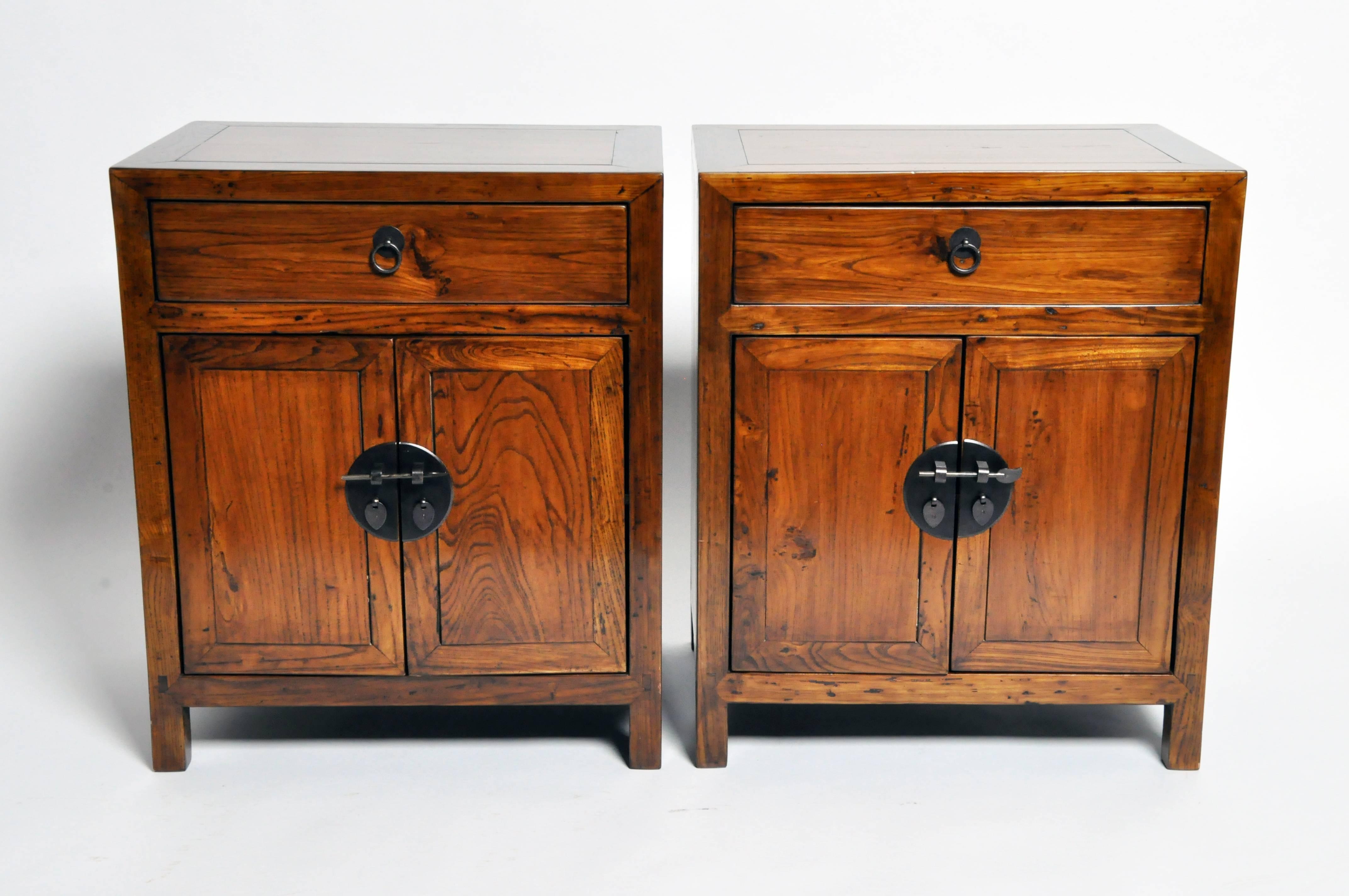 These Chinese bedside chests are made from elm wood and has been fully restored. They each features two drawers and a shelf for storage.