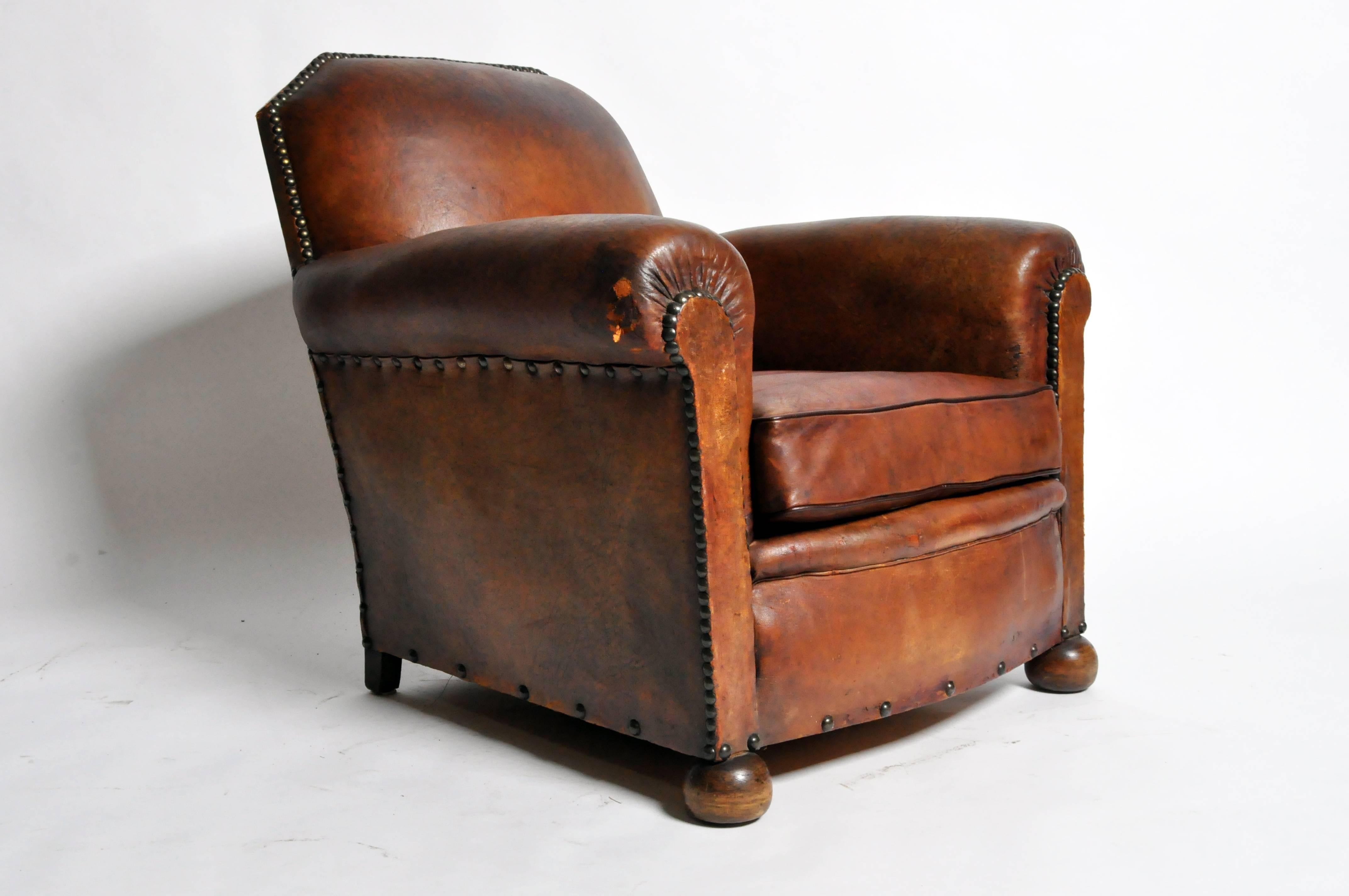 This handsome Art Deco leather chair is from Paris, France and was made from leather, c. 1940. The chair features its original leather and a beautifully aged patina. 

Additional Dimensions: 22.5" Seat Width, 23.5" Seat Depth, 25" Arm