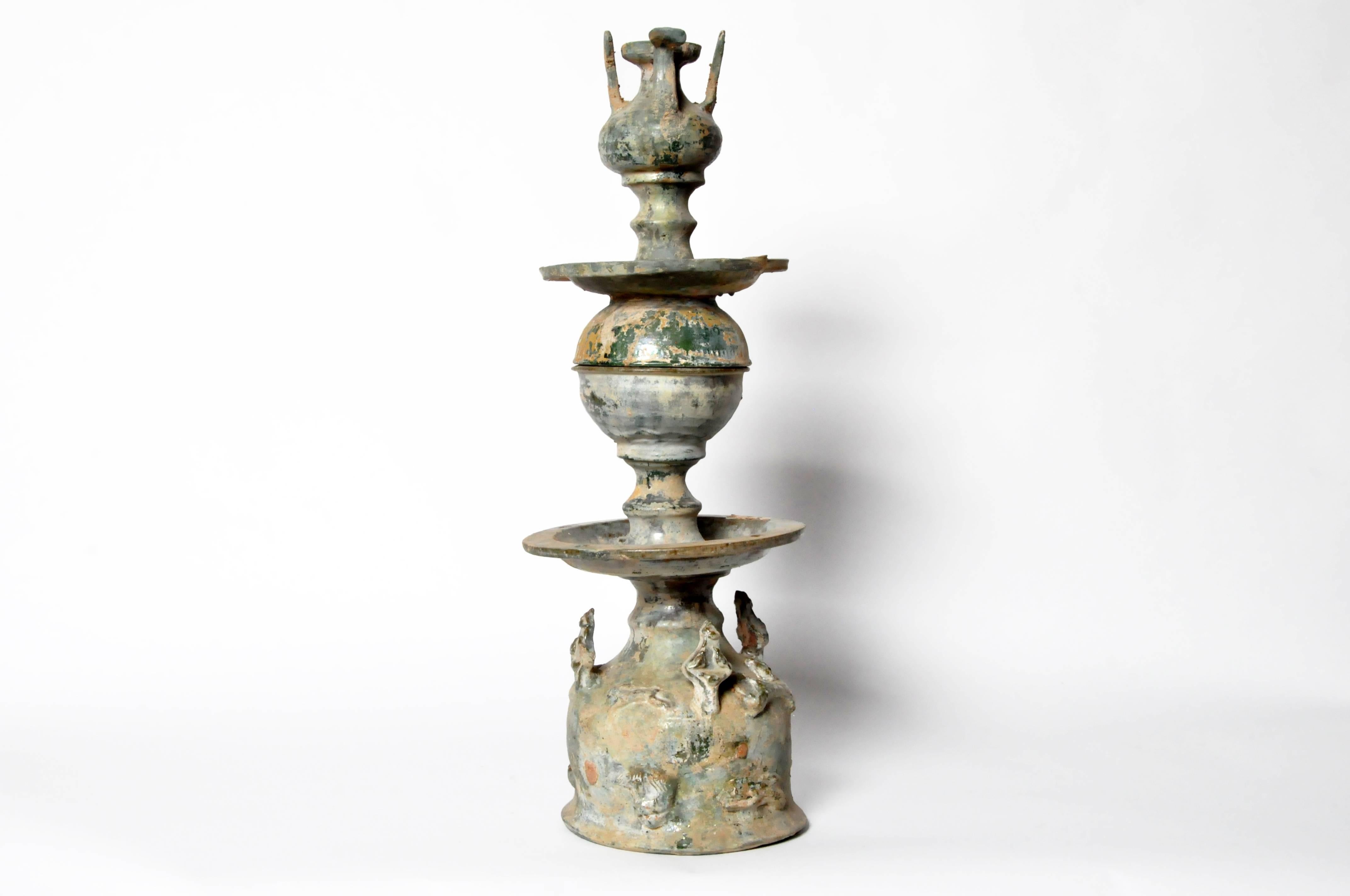 Han dynasty (206 BC – AD 220) tombs included replicas of everything necessary for the afterlife, including attendants, farm animals, vessels and various implements. This unusually large two-part oil lamp is built upon a bell-shaped base decorated