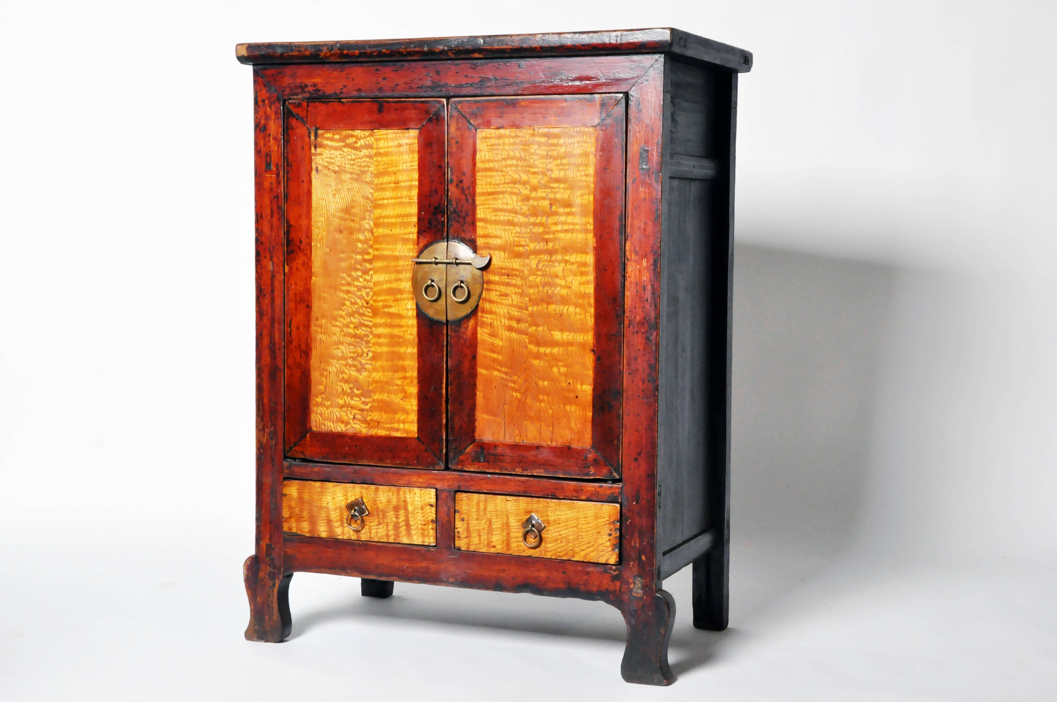 The paneled door inserts and drawer fronts feature dramatically contrasting wood grain and moon-form escutcheon with ring pulls. Handsome lines continue throughout this storage chest right down to the shapely front cabriole legs.