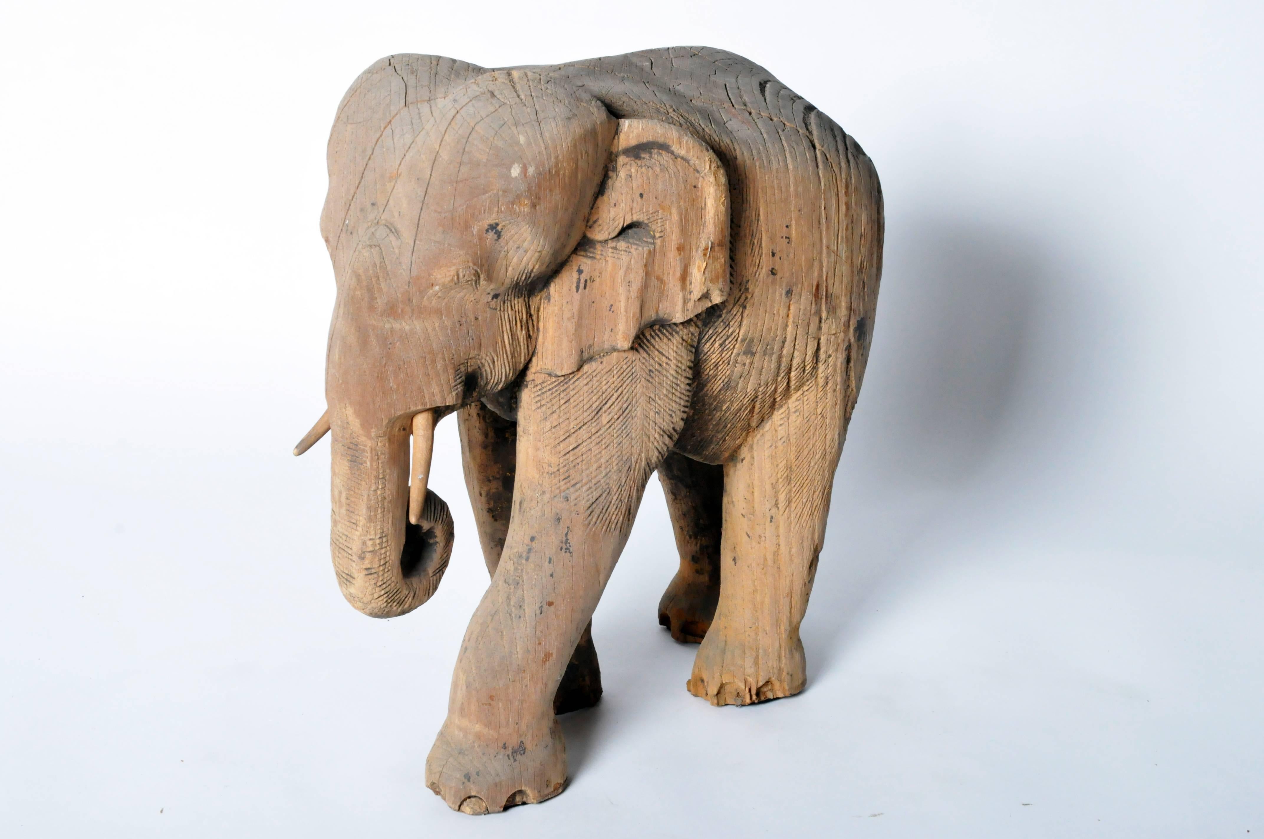 Substantial and burly, like the majestic creatures it’s modeled after, this pachyderm is hand-carved from a solid block of wood. Depicted standing with trunk curled, this large elephant has a gentle presence that is further softened by the natural
