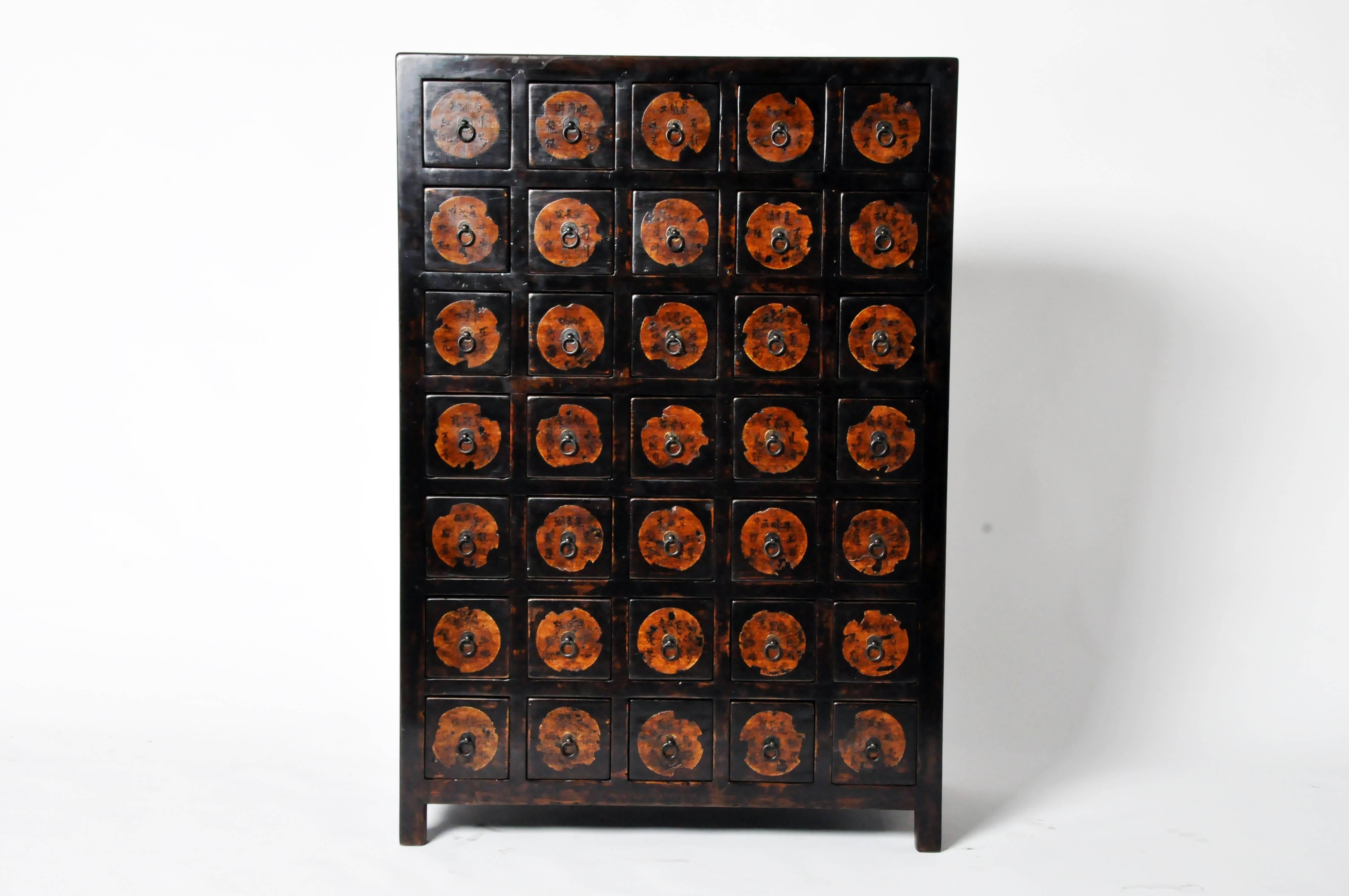 This handsome medicine chest has a rich dark lacquer throughout; each of the 35 drawers has a metal ring pull handle and is labeled with elegant calligraphy indicating the original contents of each, which kept herbs and spices organized. Constructed