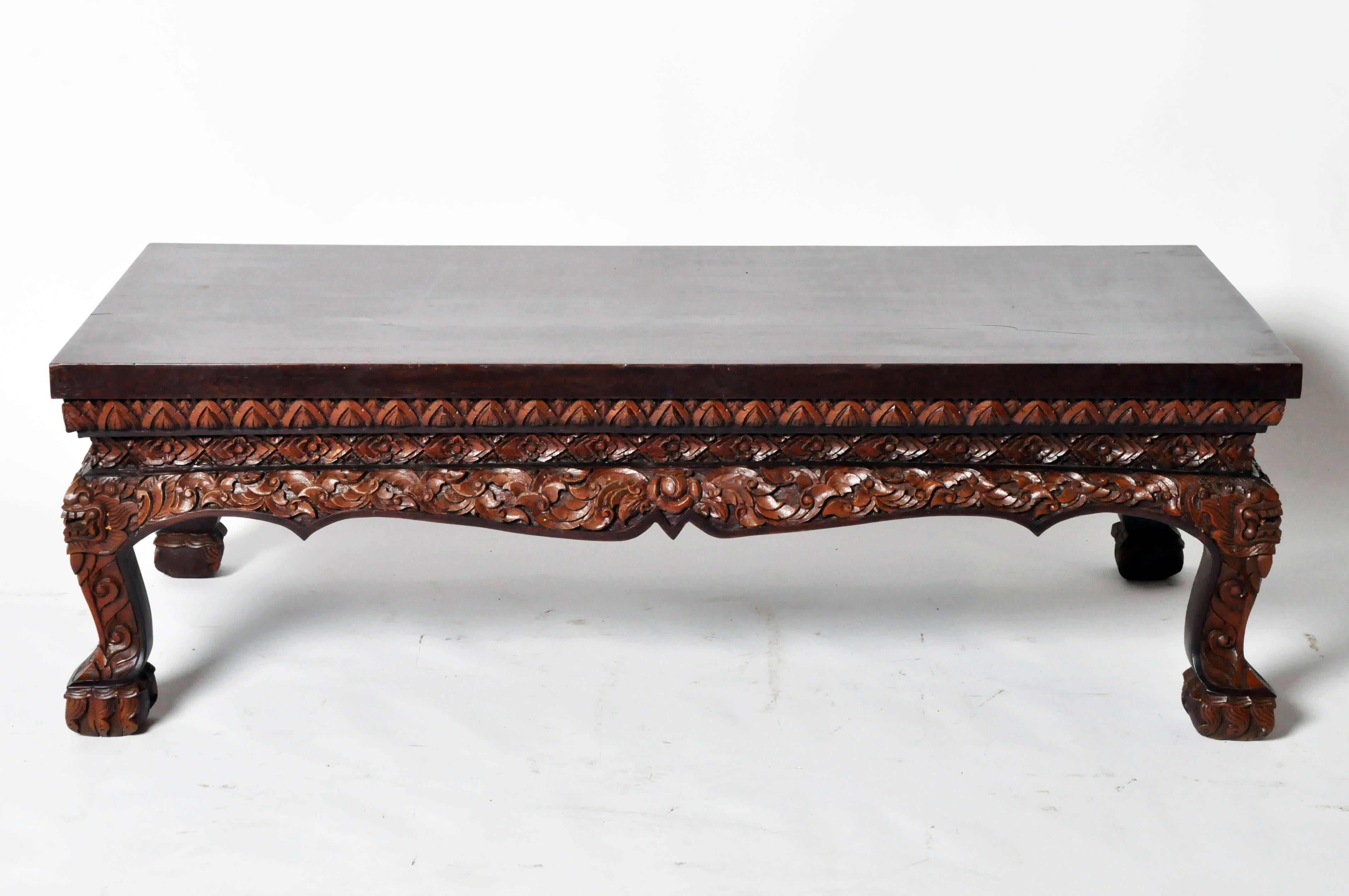 Just below the rectangular top, this coffee table has been hand-carved in a stunningly detailed floral motif that carries throughout the apron and down the squat cabriole legs.