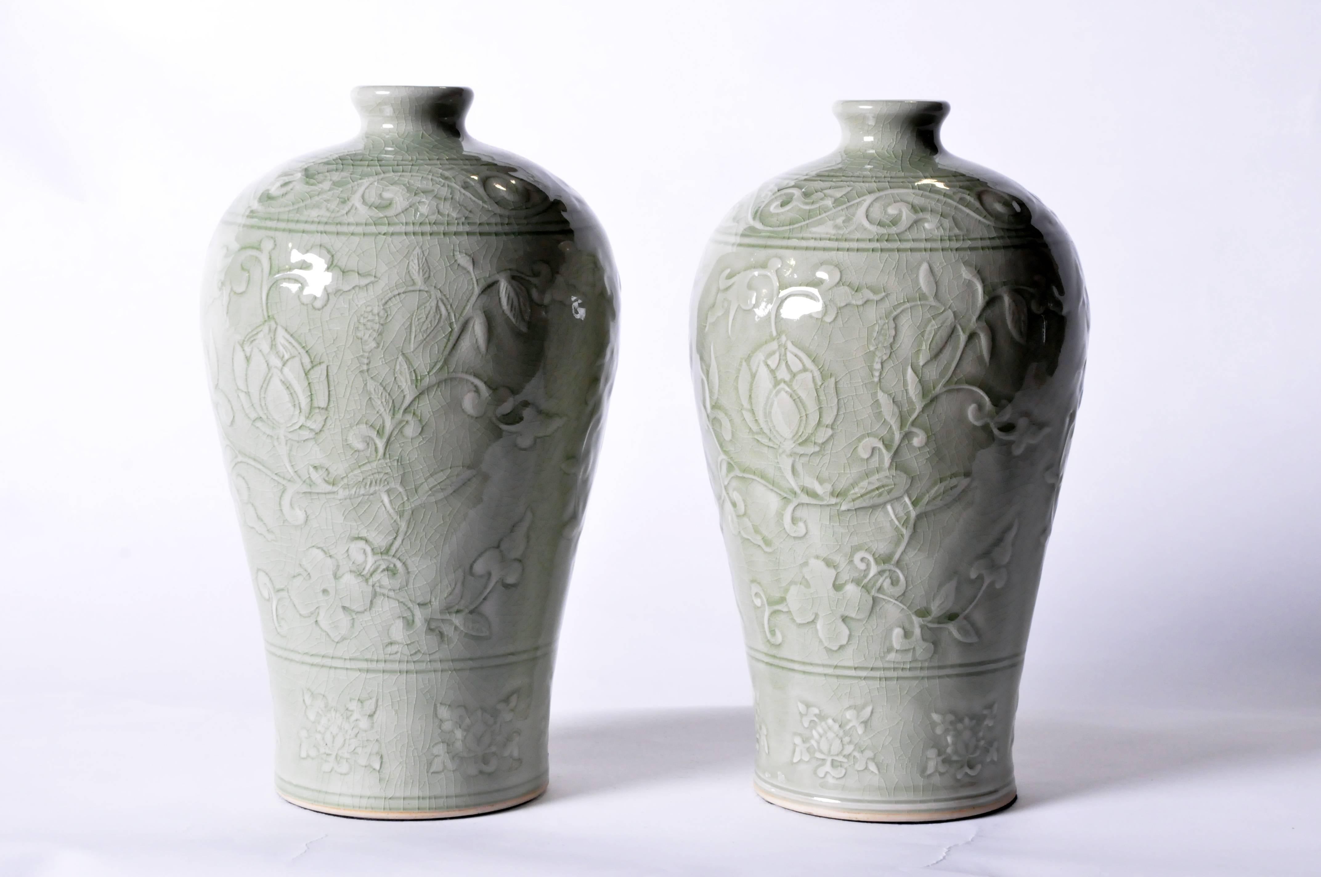 This charming handmade vessel features an allover carved lotus scroll decoration under the high-gloss crackle glaze. Shown in a pair for comparison and styling; each is sold separately.