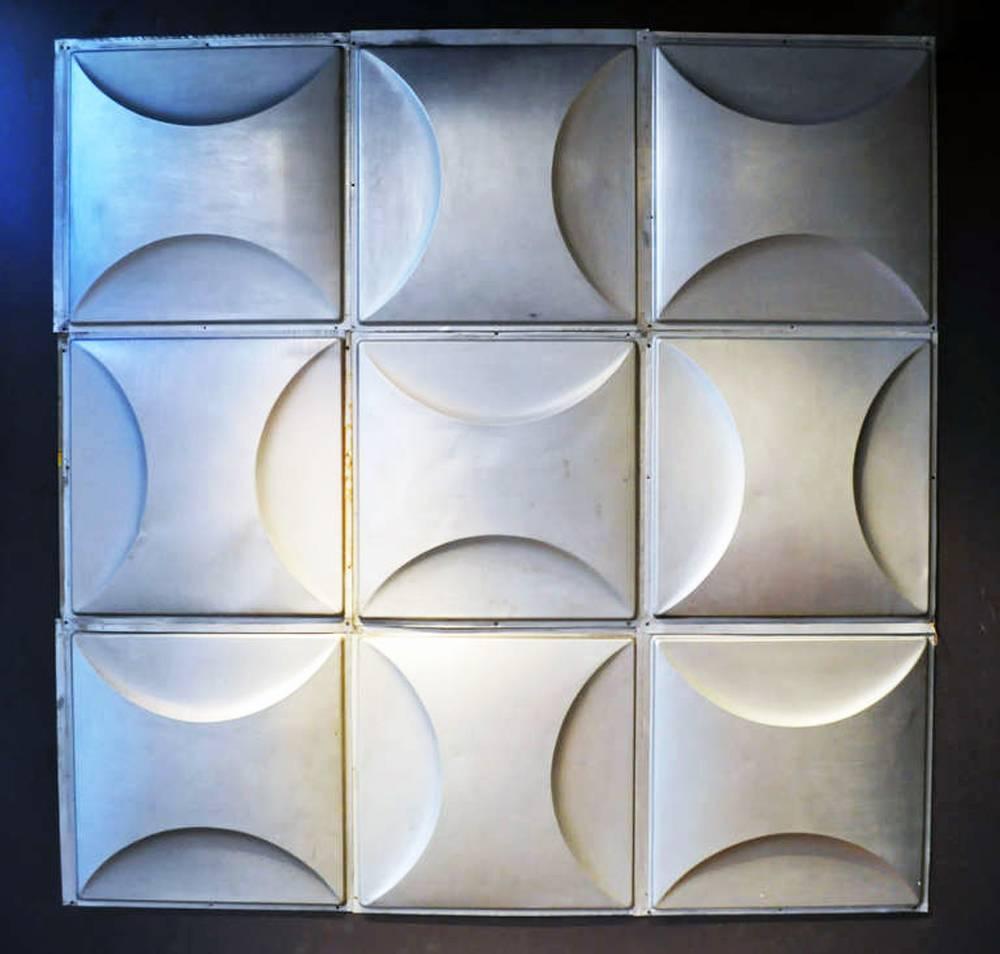 When arranged in a large grid these silvery metal squares break the mold in wall decor. The matte finish and gentle curves of each shapely surface softens the Industrial feel of these Mid-Century Modern tiles. Relatively lightweight, they can be