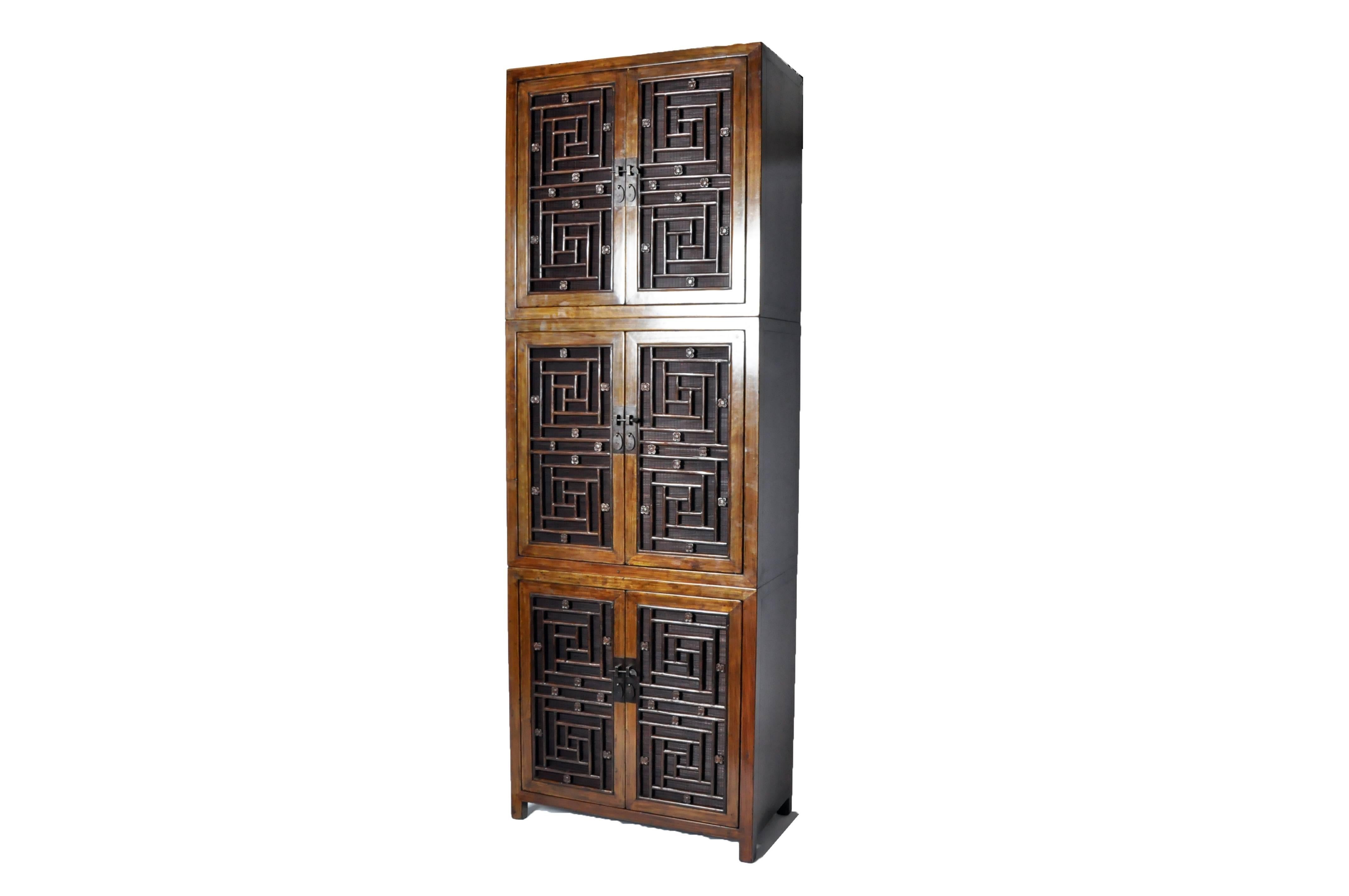 This tall Chinese lattice door cabinet is made from cypress wood and has been fully restored. It features three shelves for ample storage.