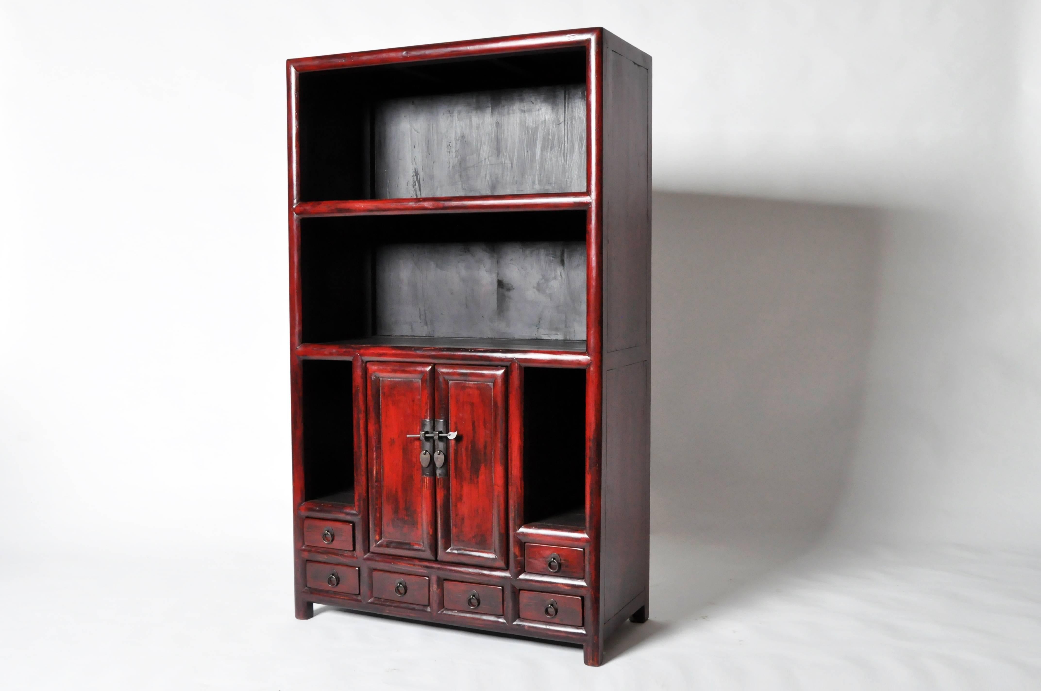 This Chinese display cabinet is made from elmwood and has been fully restored. It features display shelves and six drawers for ample storage.