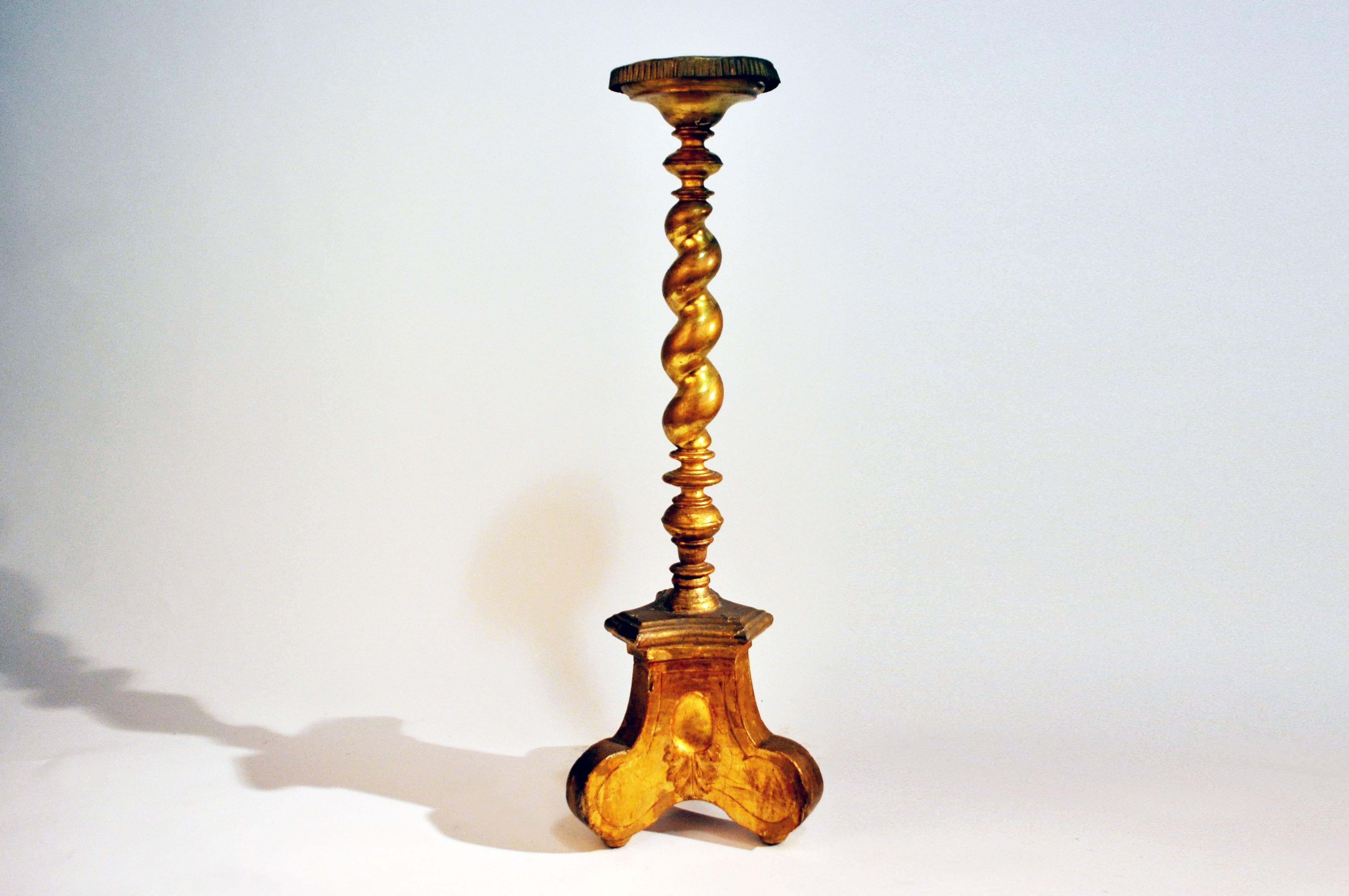 This tall candle stand features a barley twist and ring turned wood pillar, which is raised on a decorative tripod base.