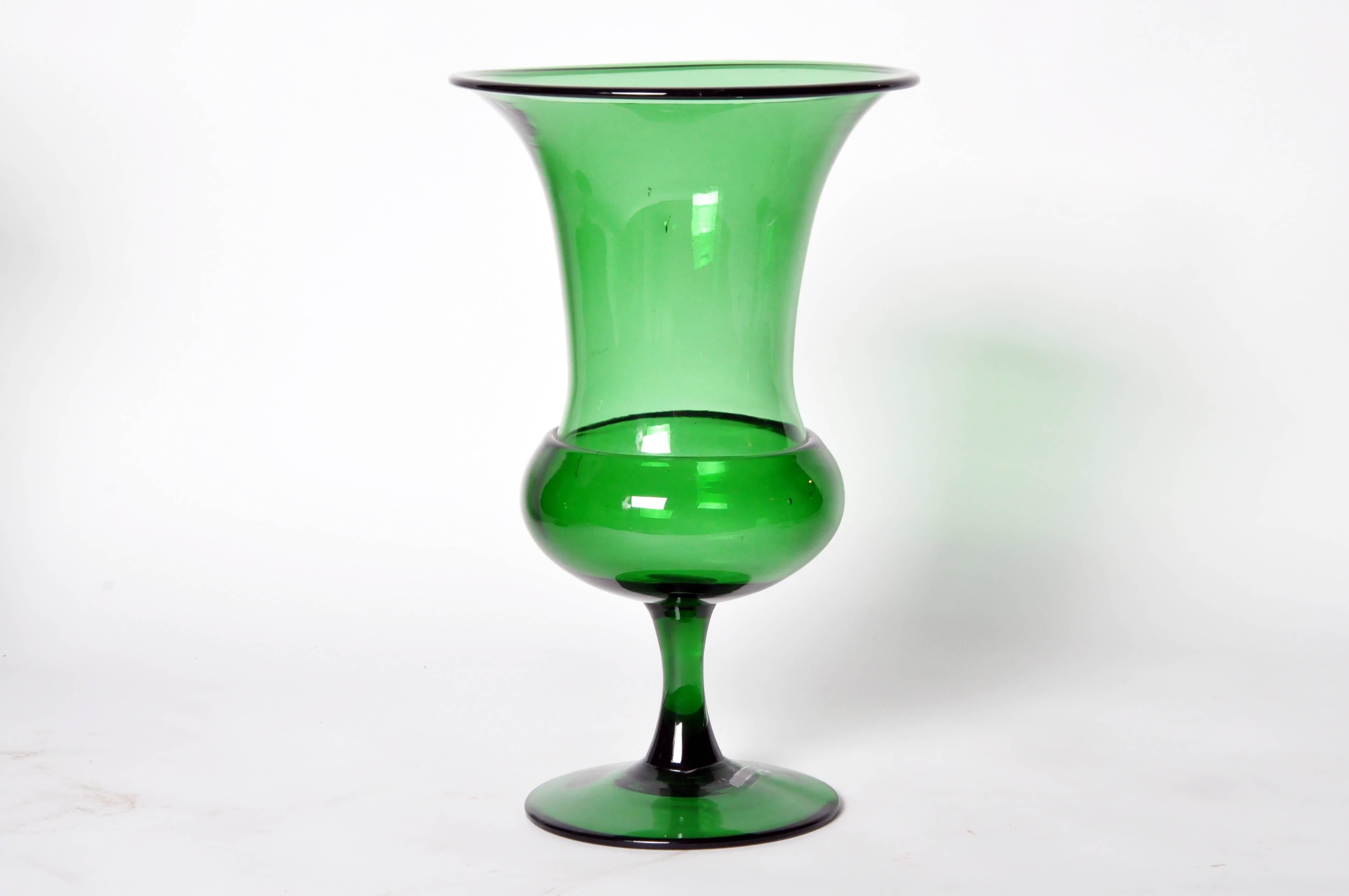 This medium glass pedestal urn has a trumpet bell flared rim. In a group or stand-alone they brighten any tabletop; the luminous emerald green perfectly pairs with fresh stems, fruit, pillar or votive candles.