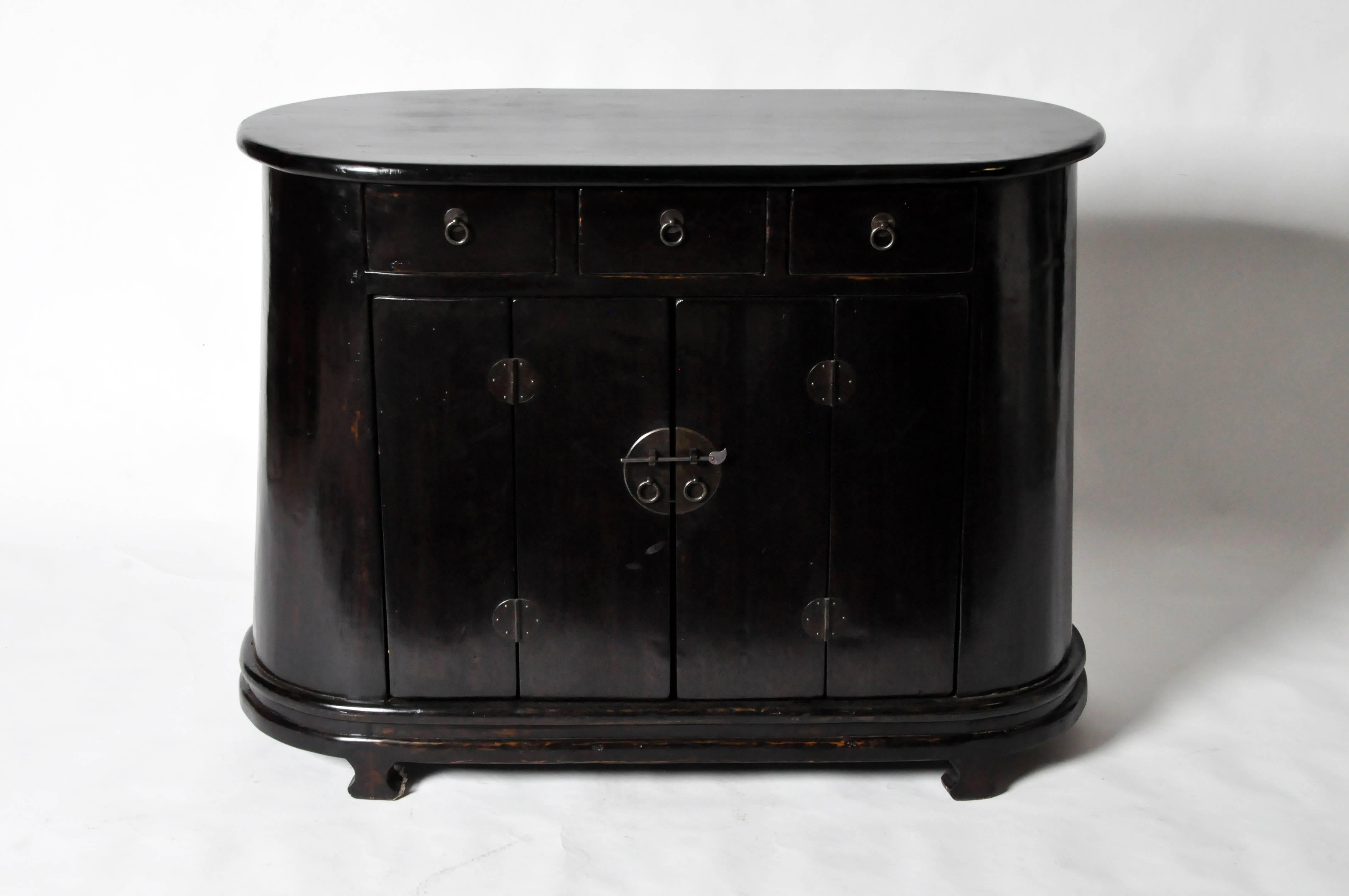 This Chinese oval shaped side chest is from Gamsu, China and is made from Cypress, circa 19th century. This piece has been restored.