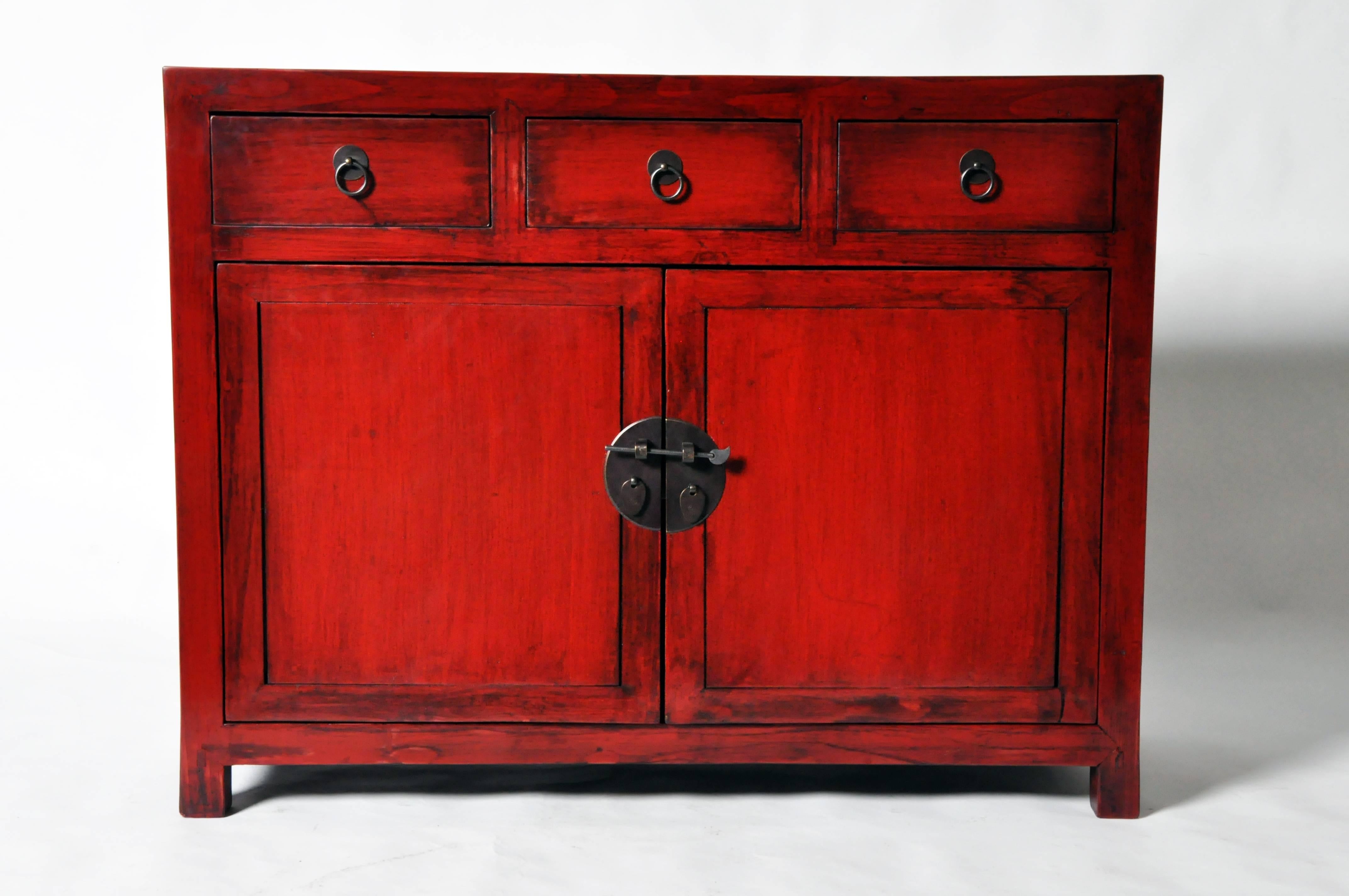 This Chinese side chest is from Henan, China and is made from elmwood and red lacquer.
