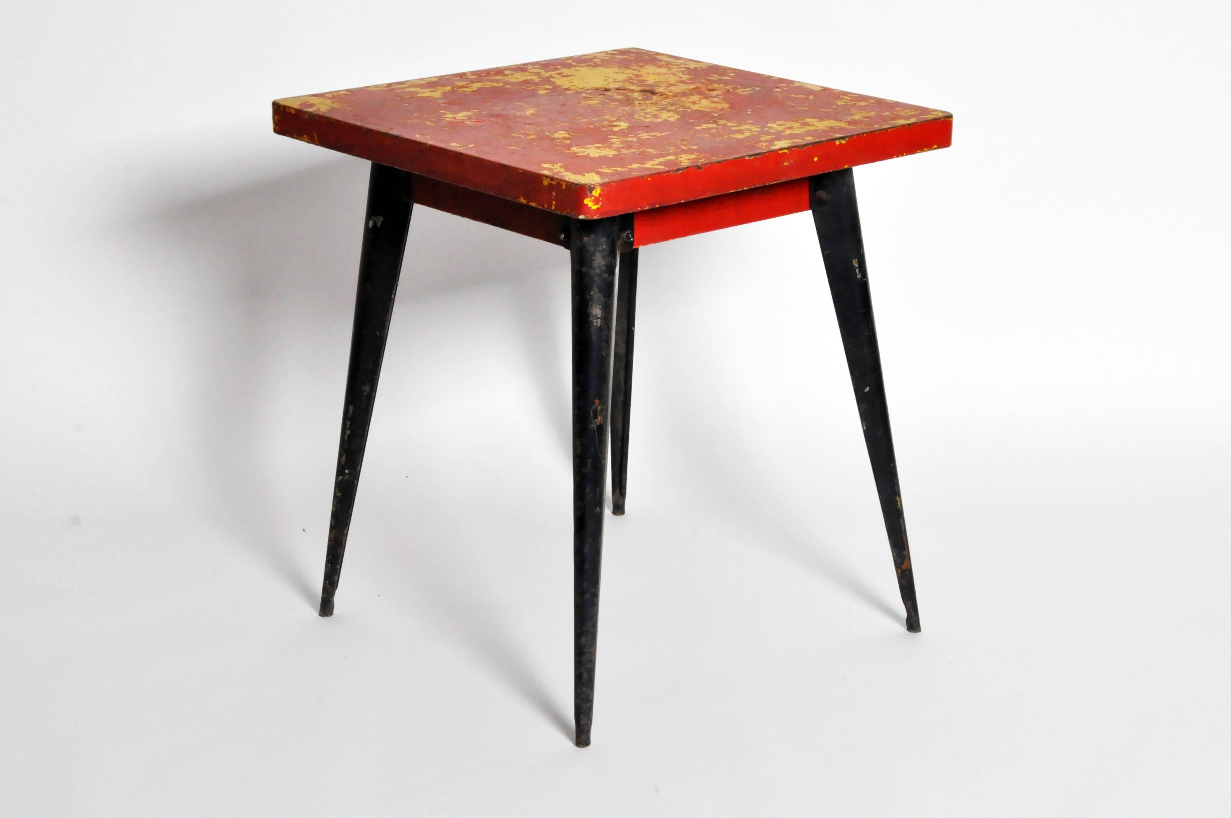 Red Metal Café Table by Tolix.  Clean, modern lines paired with beautifully-aged patina lend this piece a smart, industrial aesthetic.  Red and yellow tabletop measures 25.75