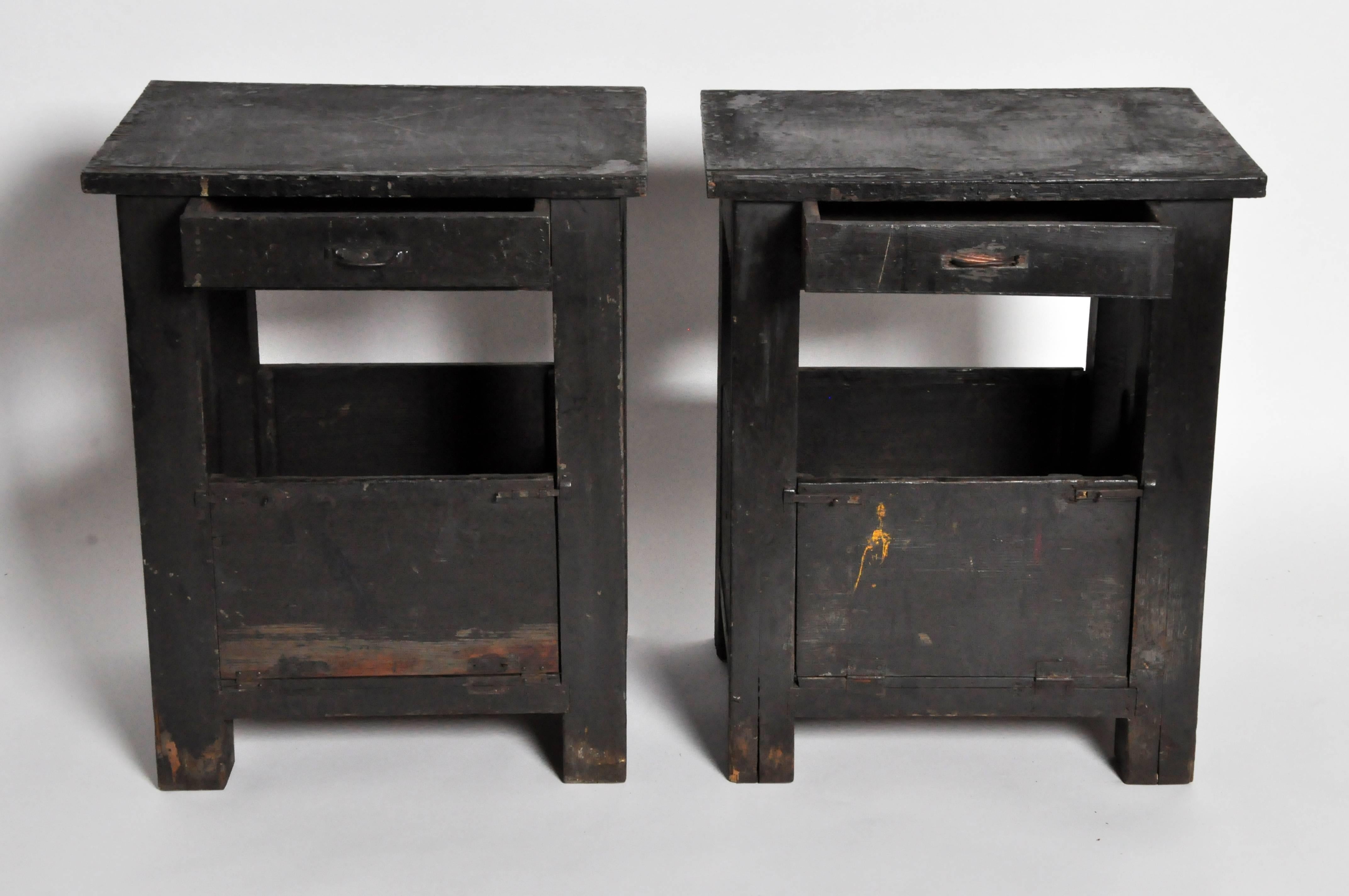 This rustic pair of bedside tables is from France and is made from pinewood and black paint, late 1800s. It features a drawer and bottom storage compartment that opens up.
