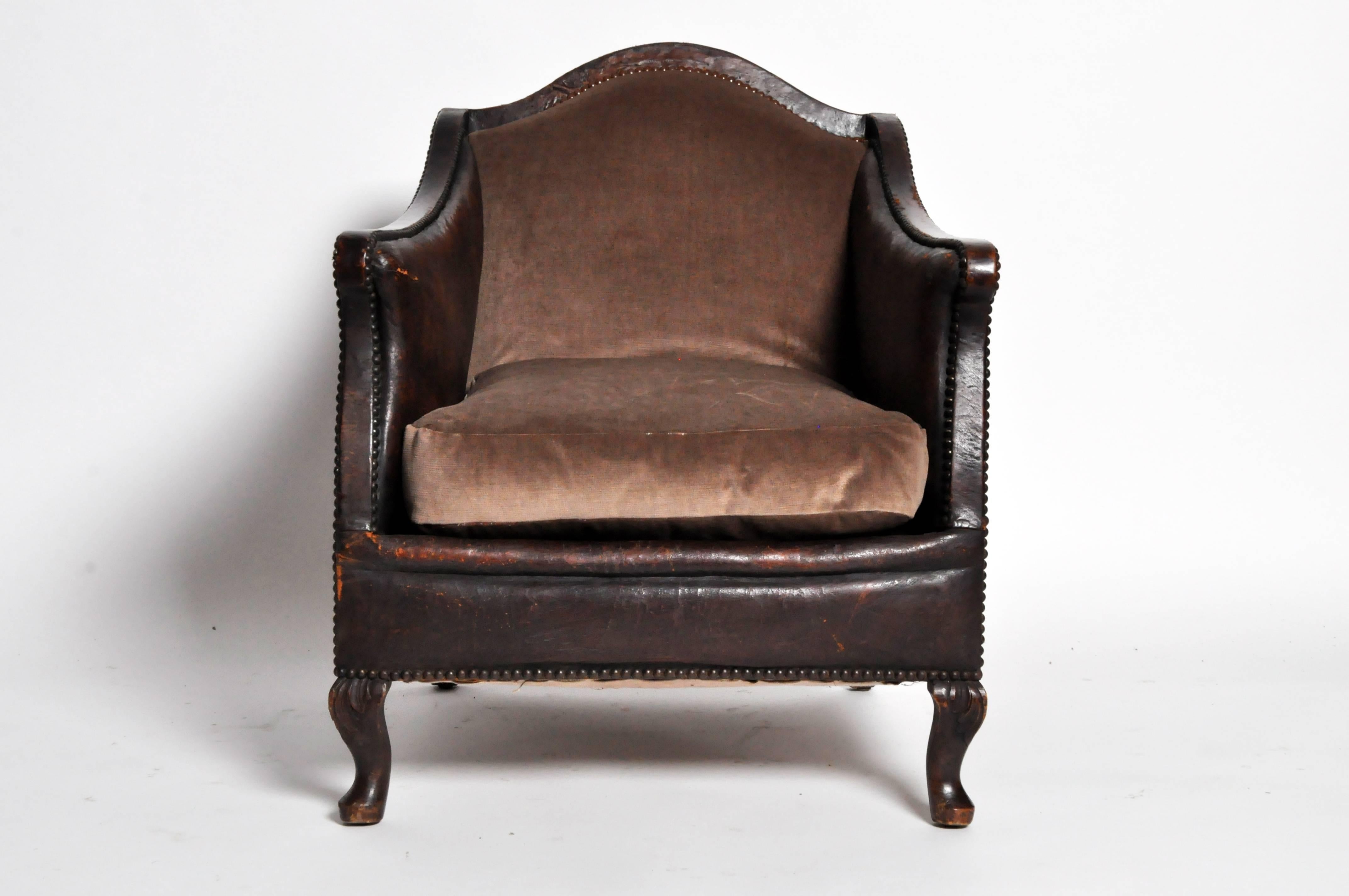 This handsome pair of leather armchairs are from France and are made from leather and cotton velvet, circa 1930. The leather features a beautiful aged patina.