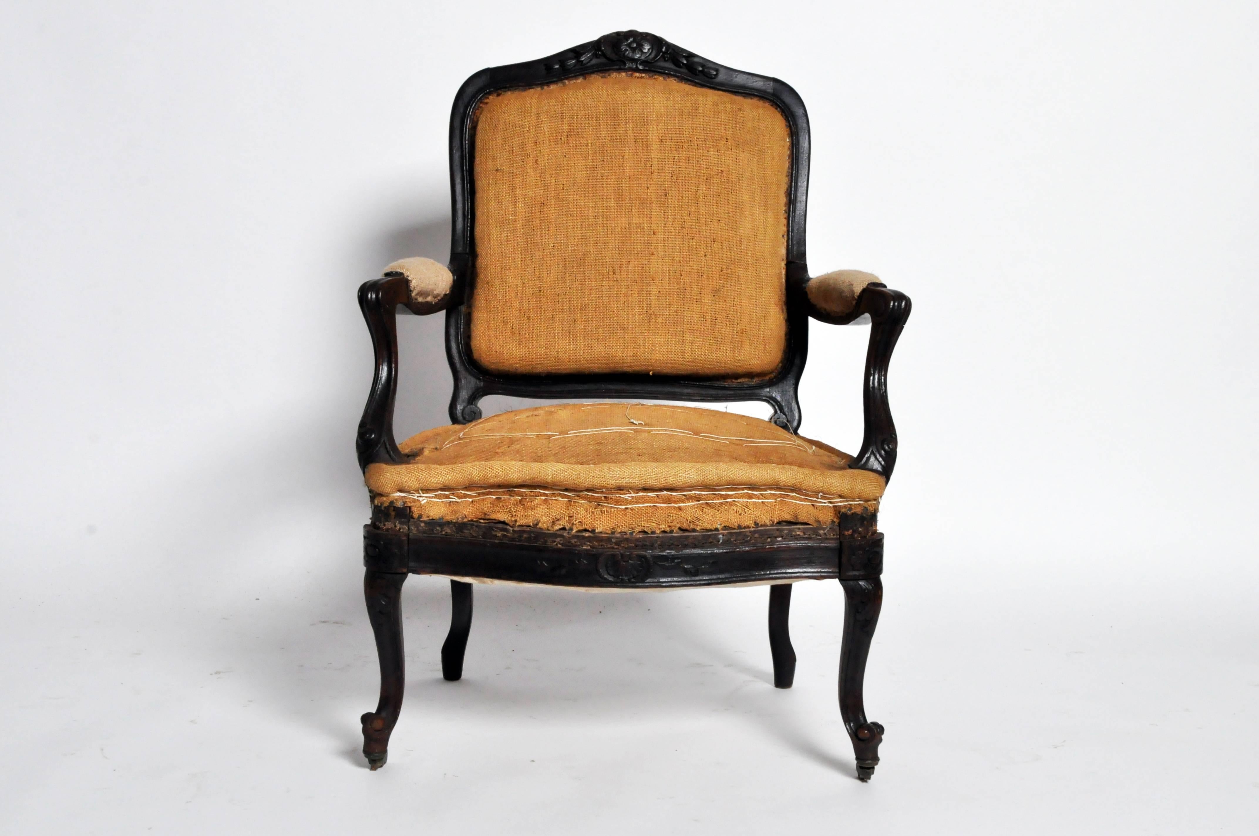 This gorgeous set of four Napoleon III armchairs represents the perfect balance of old world sophistication and antique beauty. Rich, dark wood frames, incised with stylized groves and undulating floral motifs, showcase the original backsides and