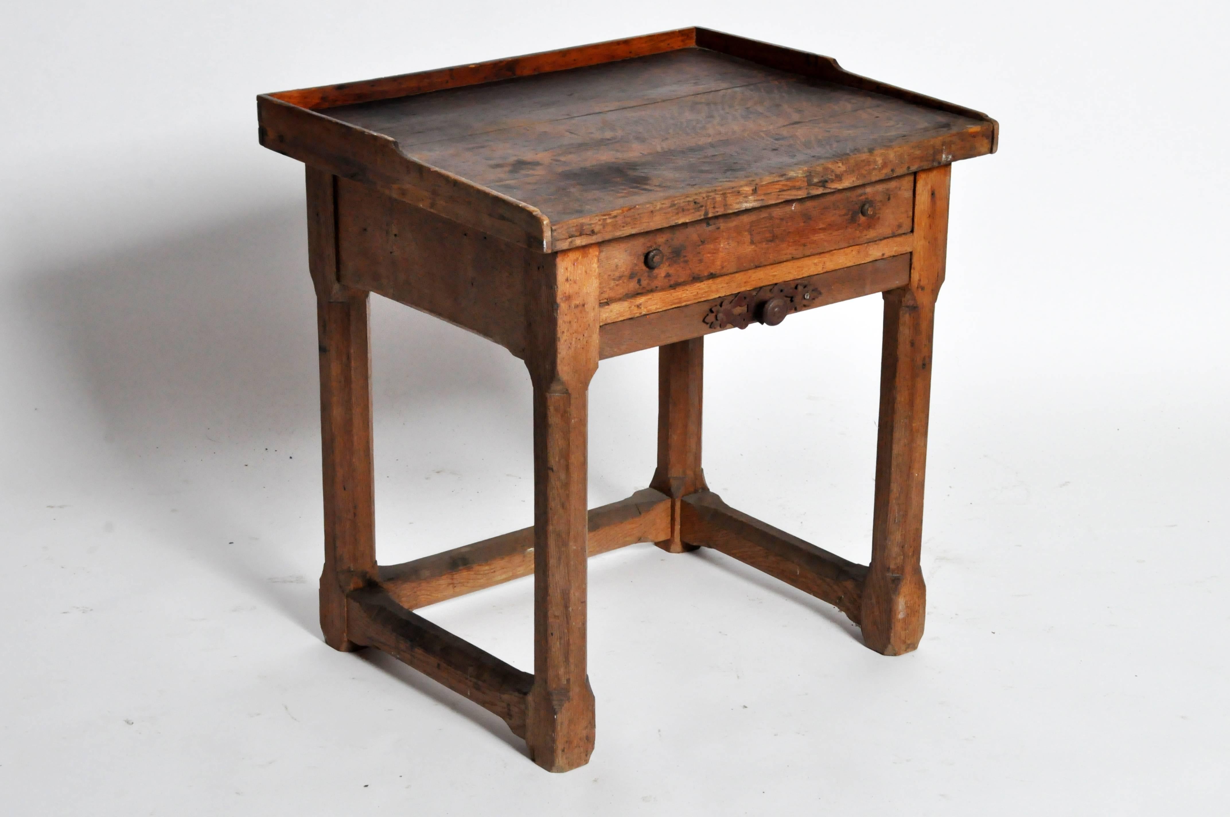 This jeweler's table is from France and is made from oakwood, circa 1900. It features two drawers for storage and chamfered legs.