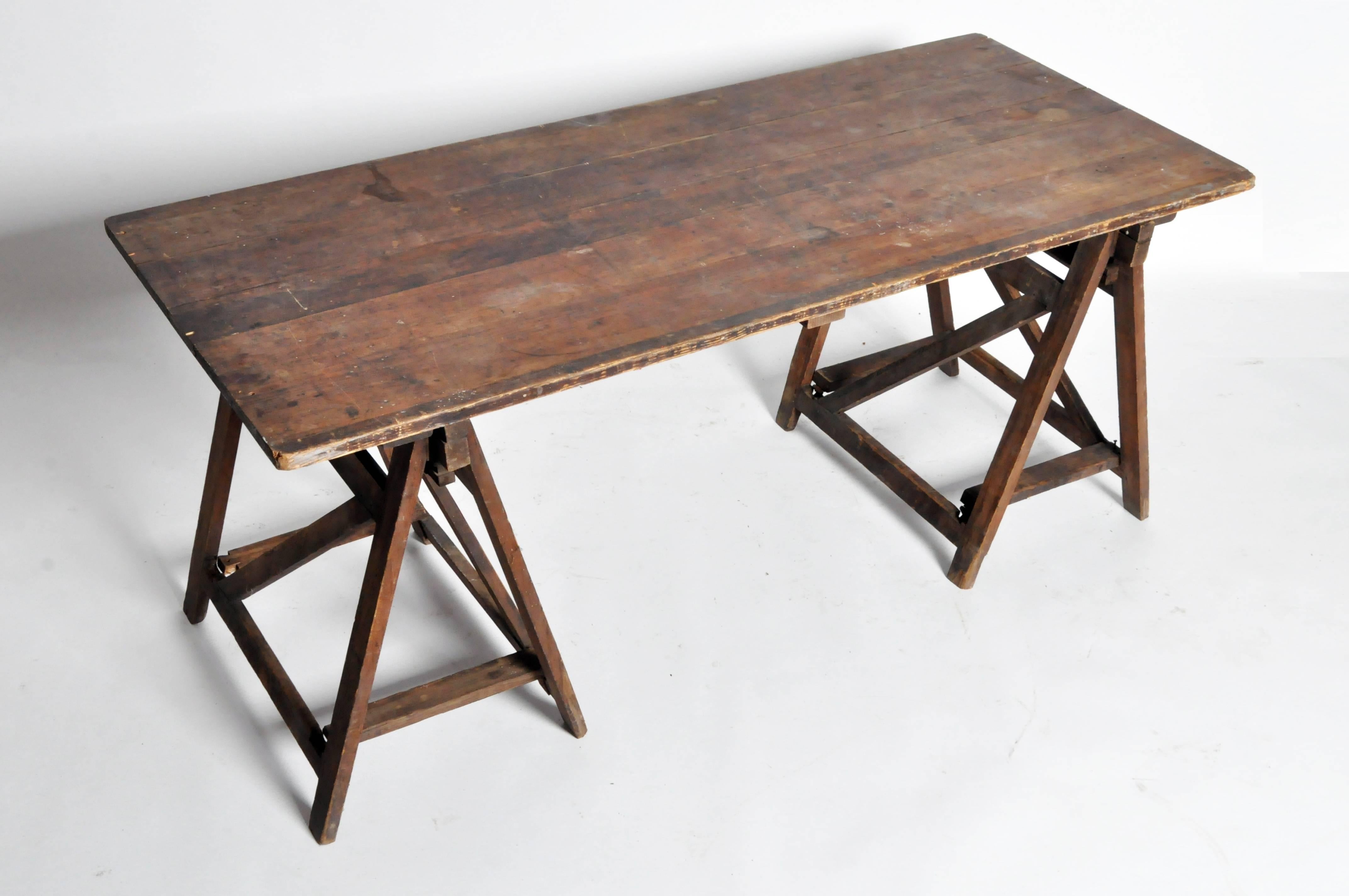 This trestle table is from France and is made from pinewood. The table comes in three pieces the top and the two leg bases. The tables a beautiful aged patina.
