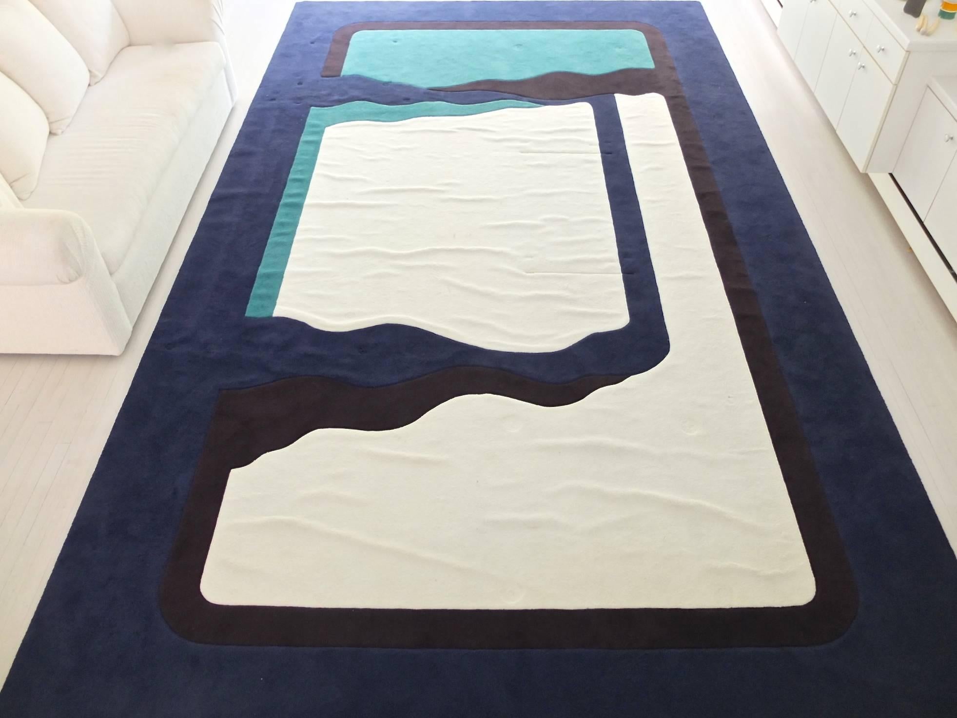 Custom thick pile wool rug in the style of Edward Fields for glamorous living room with Karl Springer meets Robert Motherwell vibe.
Size 10 ft by 17 ft.
Colors: Navy blue, black, teal green and white-ish.
The white spaces have several raised linear