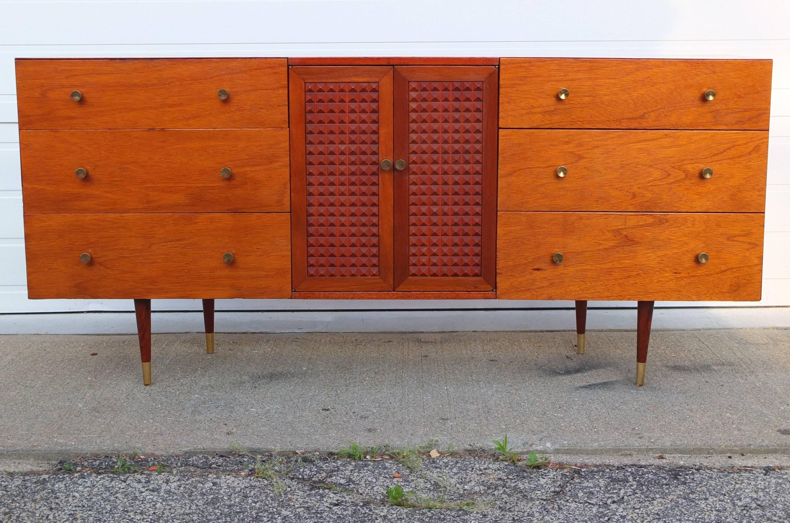SATURDAY SALE no further discounts

Mid-Century Modern long low dresser with two stacks of three drawers and a center open cabinet with nubbed textured door panels.
The wood appears to be walnut that has been clear varnished or perhaps stained with