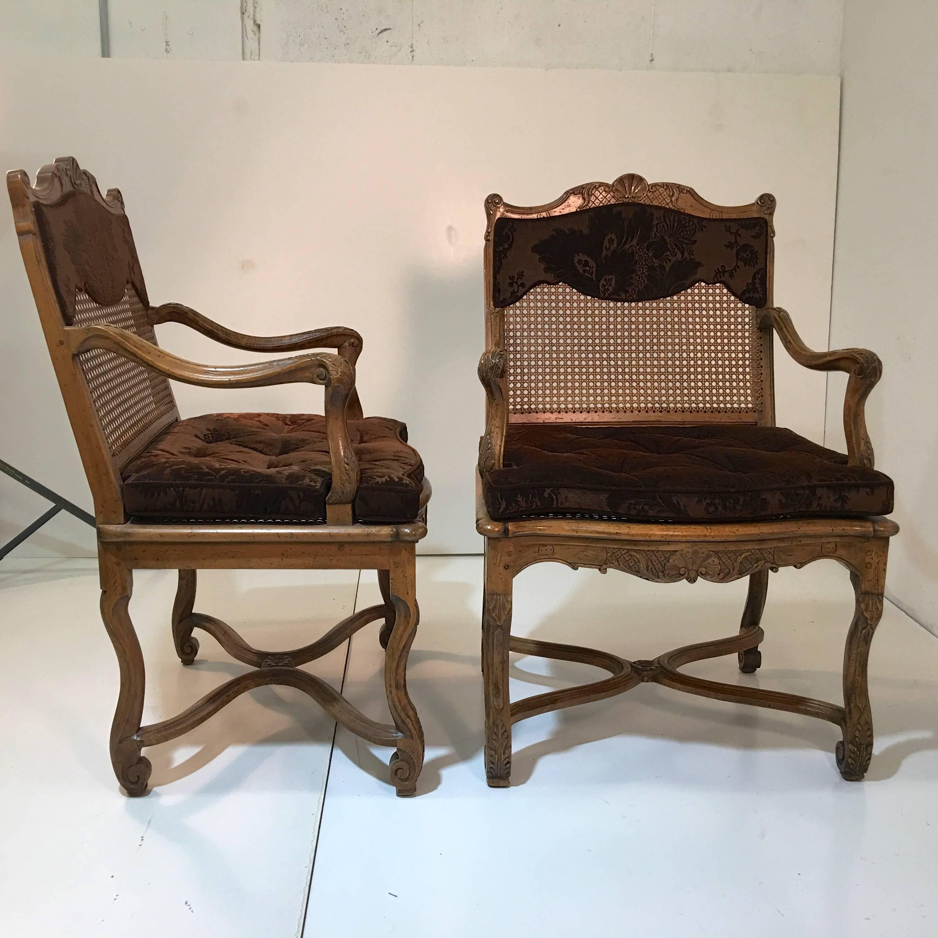 Set of ten dining armchairs by legendary carver Don Ruseau Inc., New York City. 
Provincial Louis XV style with caned backs and seats. Hand carved and all joints pegged, not glued. 
Fitted with custom seat cushions in brown cut velvet. (Comes with
