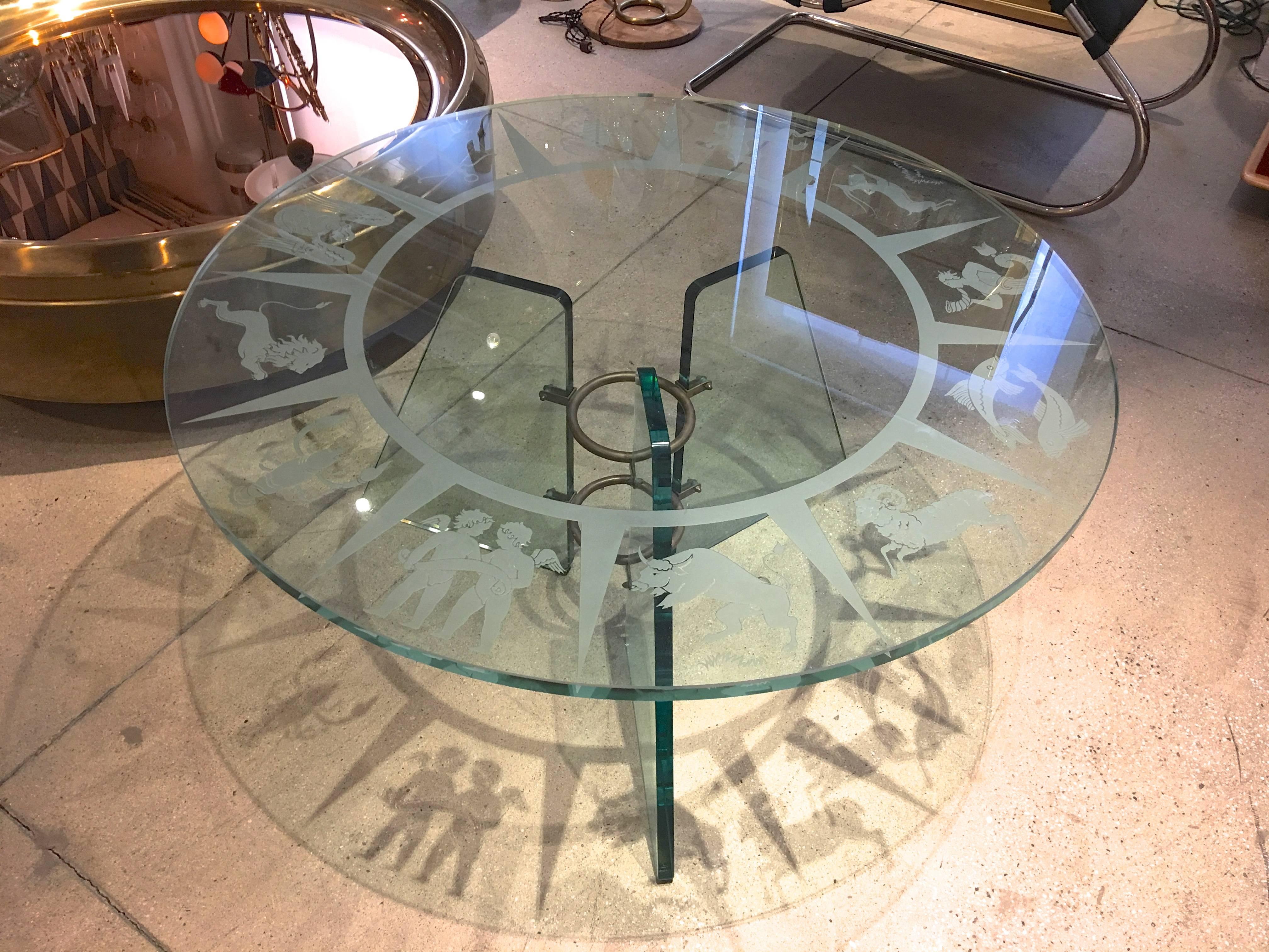 1930s Italian etched glass table attributed to Pietro Chiesa for Fontana Arte.

39 inch diameter glass top deeply engraved and etched with stylized Italian Art Deco zodiacal figures.

Base is comprised of three 20 inch high irregular quadrilateral