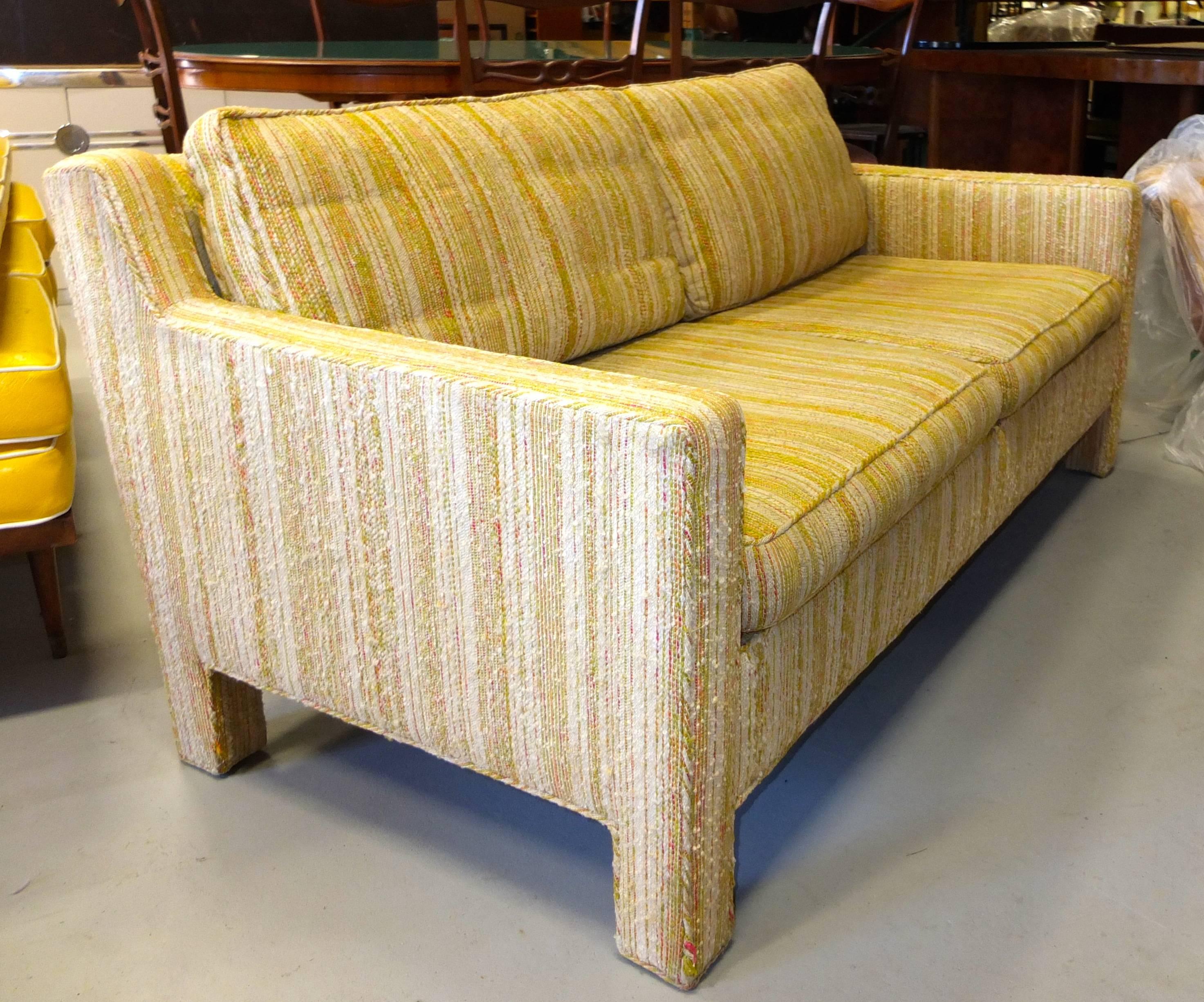 Chic early 1960's two cushion love seat sofa with original upholstery and original Dunbar decking, designed by Edward Wormley for Dunbar.  Two down filled loose back cushions.  Foam filled seat cushions.  Two sets of arm rest protectors.  Raised on