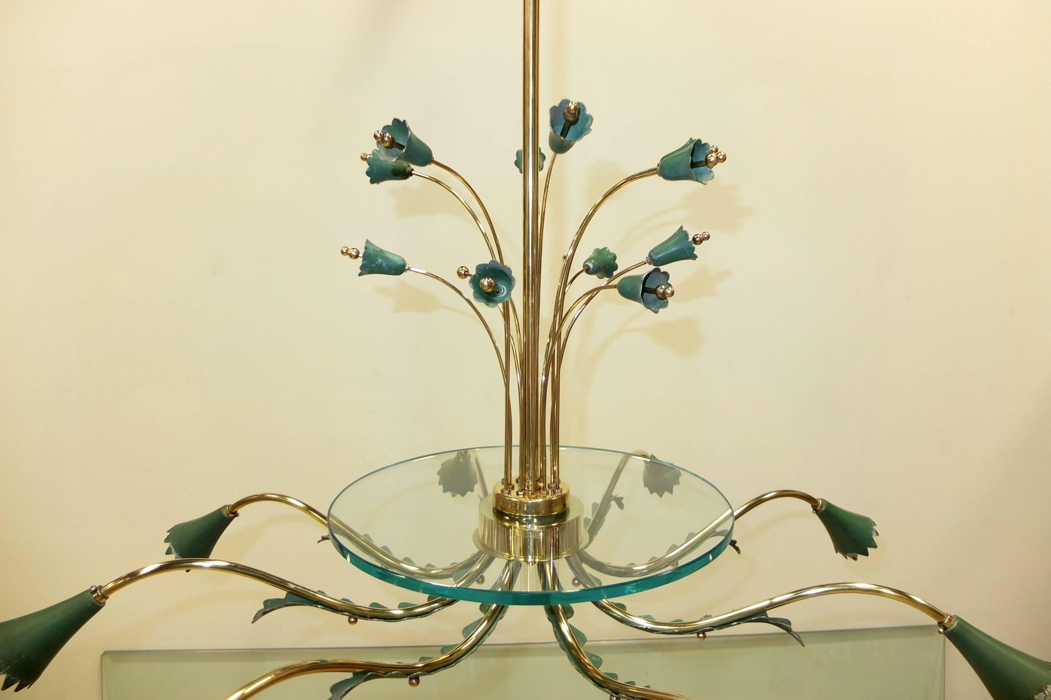 Italian 1950's eight arm chandelier in the style of Arredoluce with eight brass scrolled arms embellished with acanthus leaves terminating with eight painted aluminum cones with cerated edges.  Above the cluster body is a clear crystal disk on top