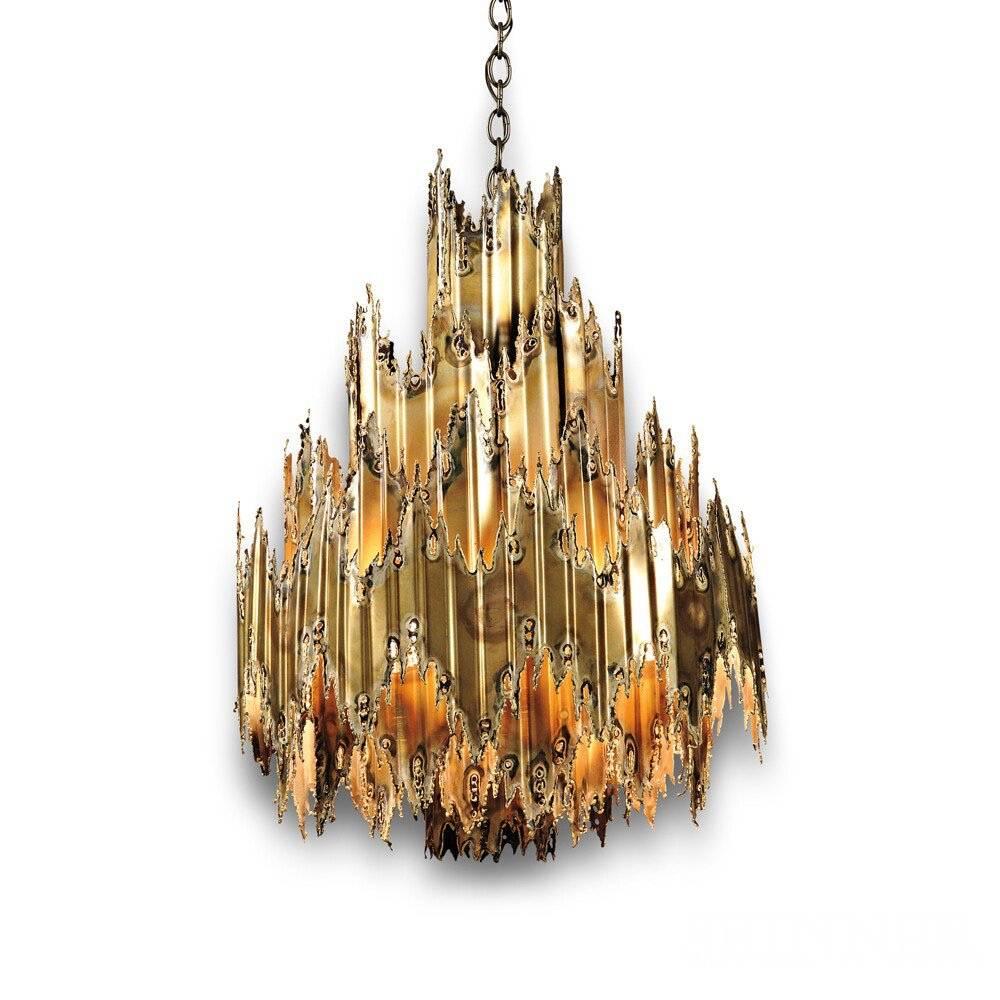Large scale 1960's brutalist chandelier in torch cut brass tiered with four concentric rings by metal sculptor Thomas A. Greene who created the beautiful patina with an oxyacetylene torch

T. A.  Greene started working with metal as a dental