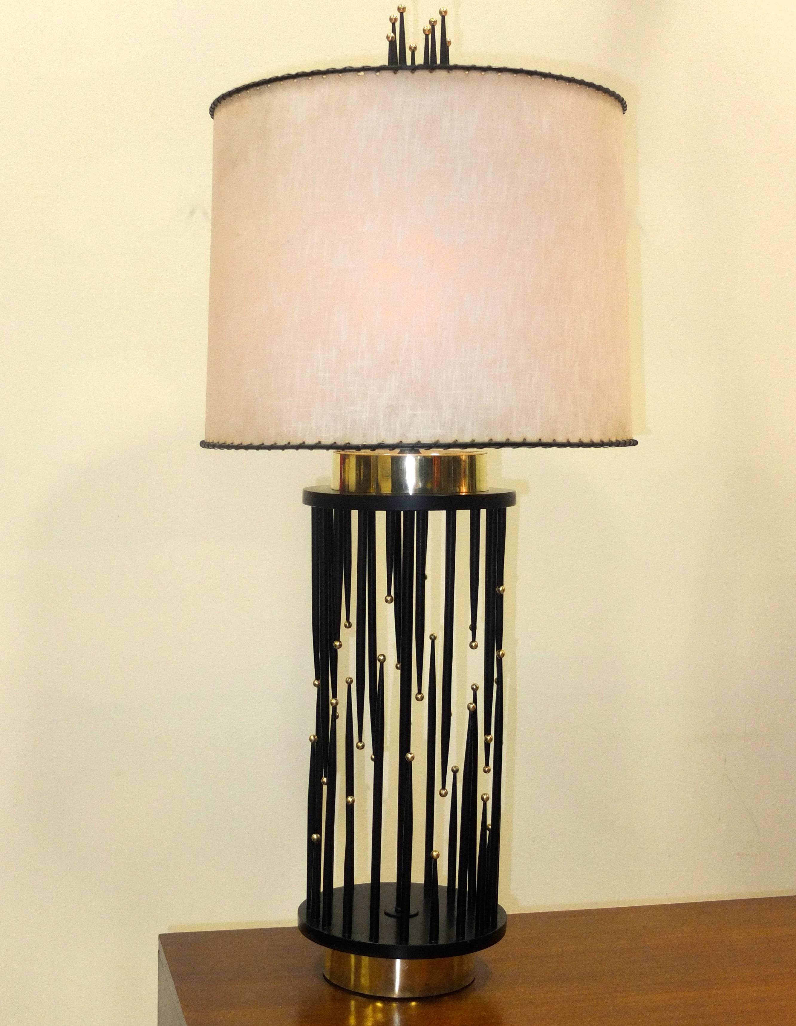 Visually striking vintage 1960's table lamp with a cylindrical base composed of tapered black pointed spikes which are painted wooden dowels at irregular heights and each with a solid brass ball on its tip.  Brass recessed drum base and top and a