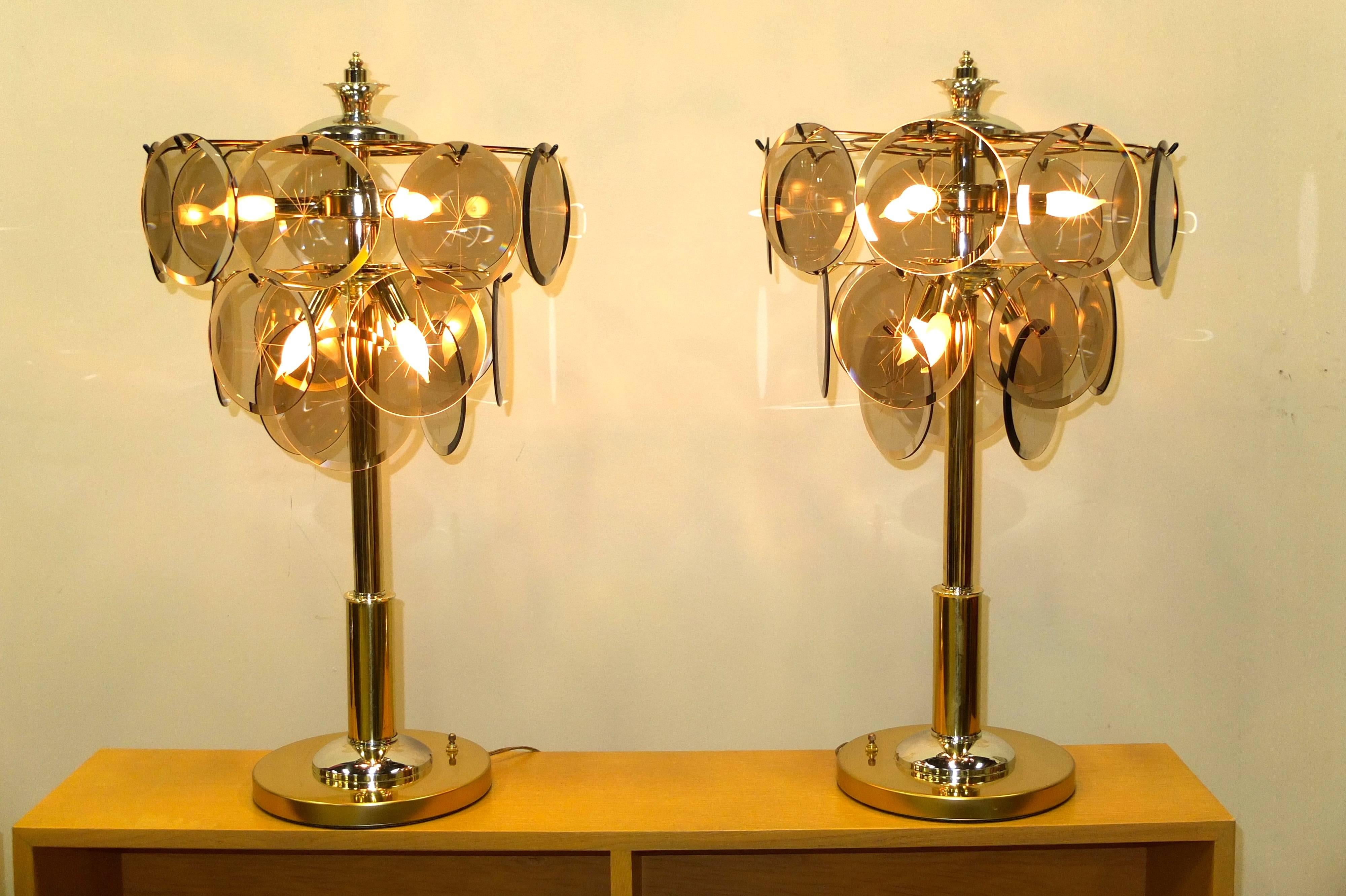 These vintage table lamps are in immaculate, almost new old stock condition. Produced by Triarch Miami inspired by Vistosi's famous Murano glass disk chandeliers, tall art deco style columns in chrome and brass plate rise to a double tier scaffold