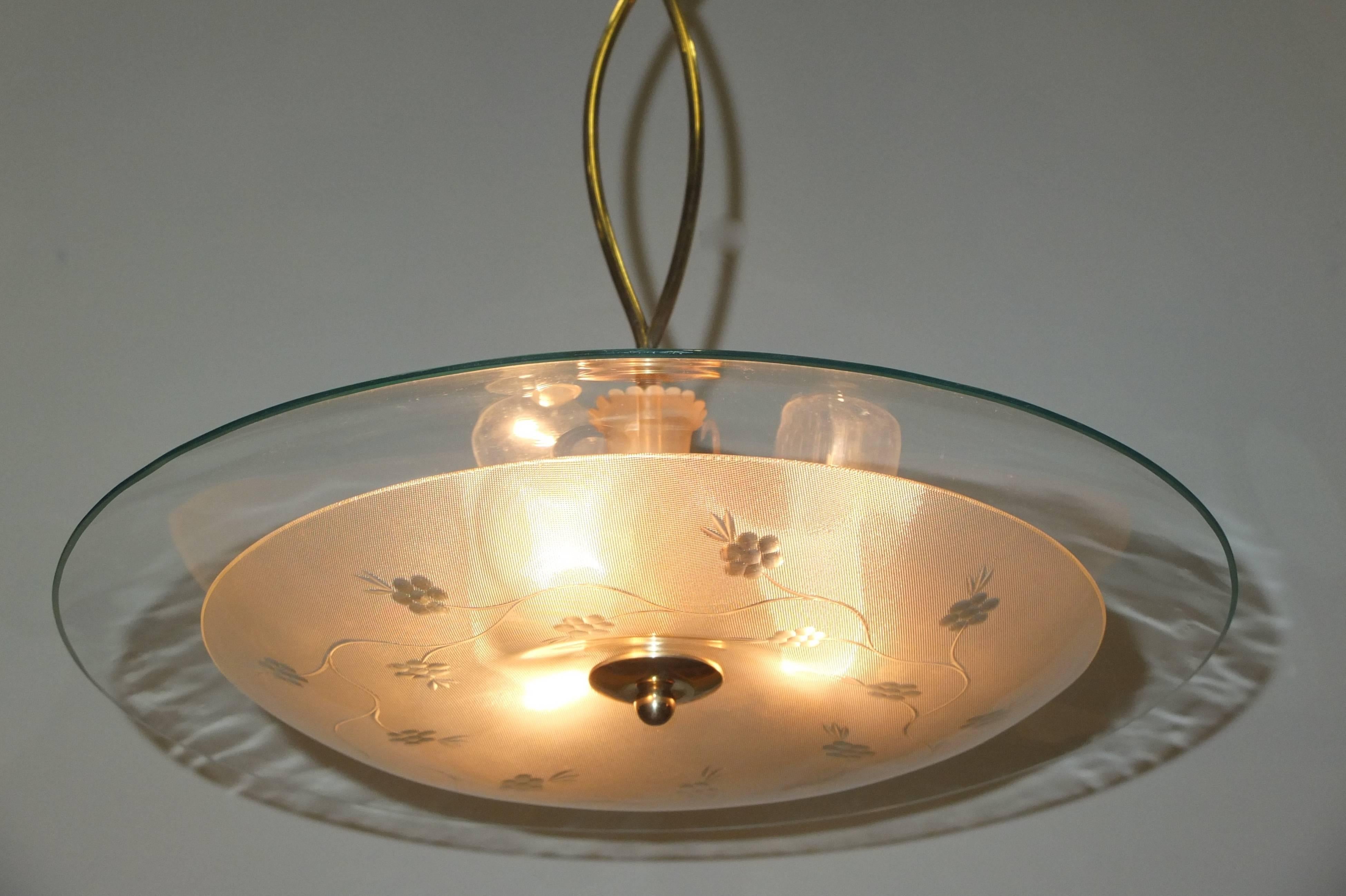 Gorgeous early 1950's Italian chandelier in the manner of Pietro Chiesa and Max Ingrand of Fontana Arte in the form of a flying saucer with clear crystal top and textured glass venturi shaped bowl with subtle etched flowers.  Most unusual is the