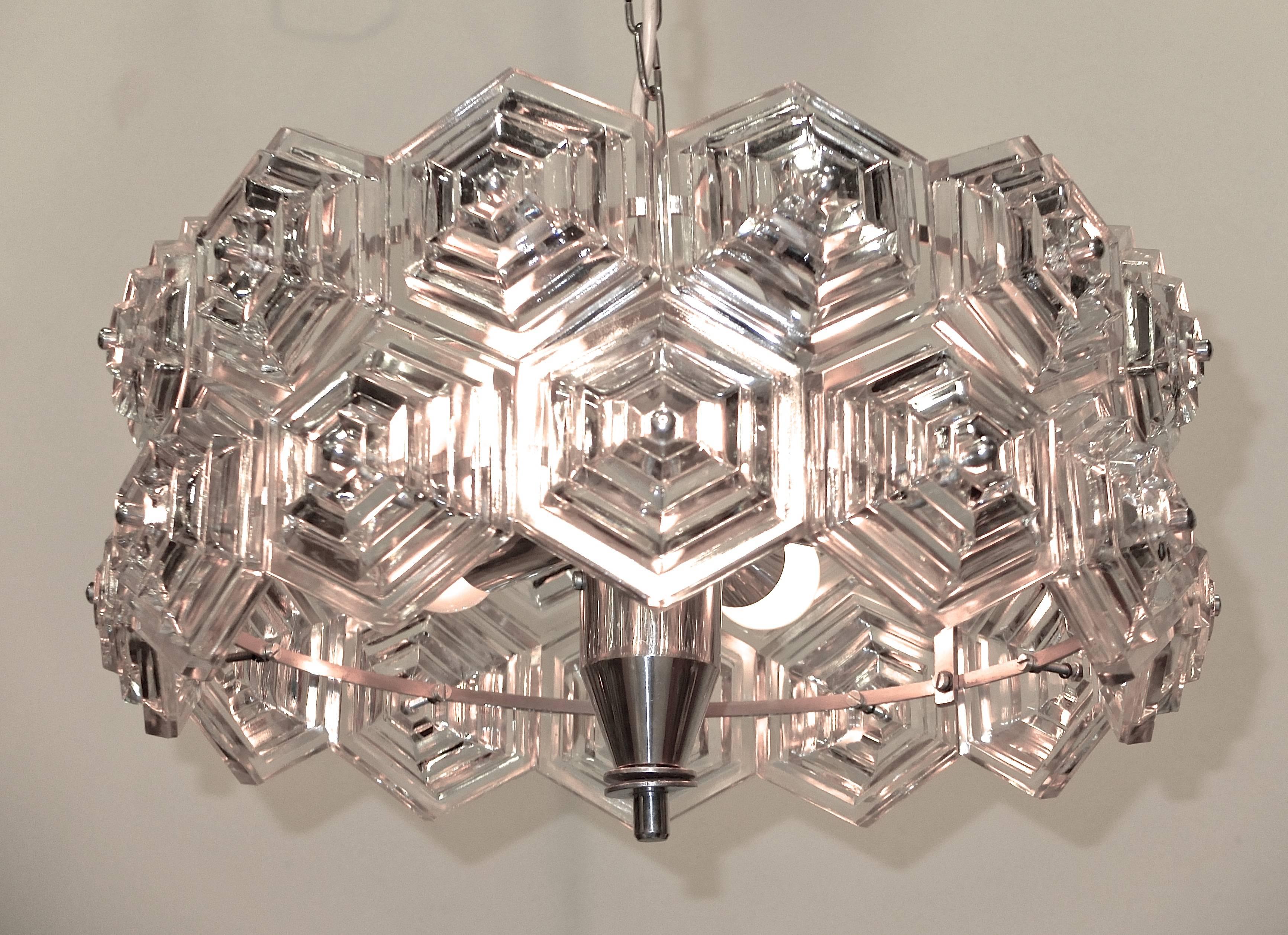 1960s crystal pendant or flush mount produced by VEB Kristalleuchte in the GDR featuring stepped hexagonal glass prisms on a chrome frame.

Rewired/Takes six candelabra size bulbs up to 60 watts each.

Comes with original ceiling canopy and