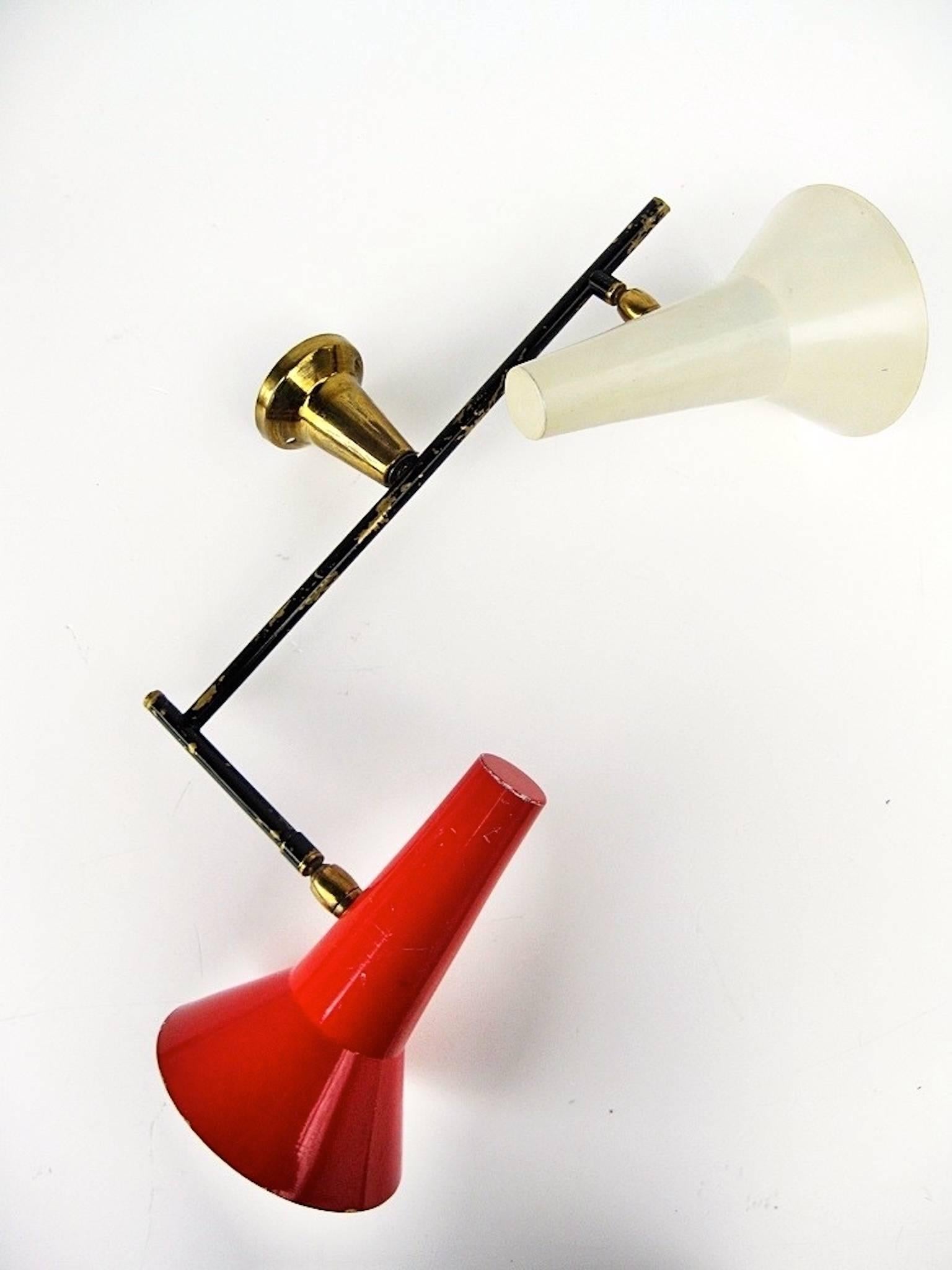 Impressive vintage 1950s Italian homage to Gino Sarfatti's 169/2 wall sconce for Arteluce, 1952.

Brass flanged conical mount, black enameled brass armature with attractively distressed enamel, two spun aluminum lamp heads, one red, one white,
