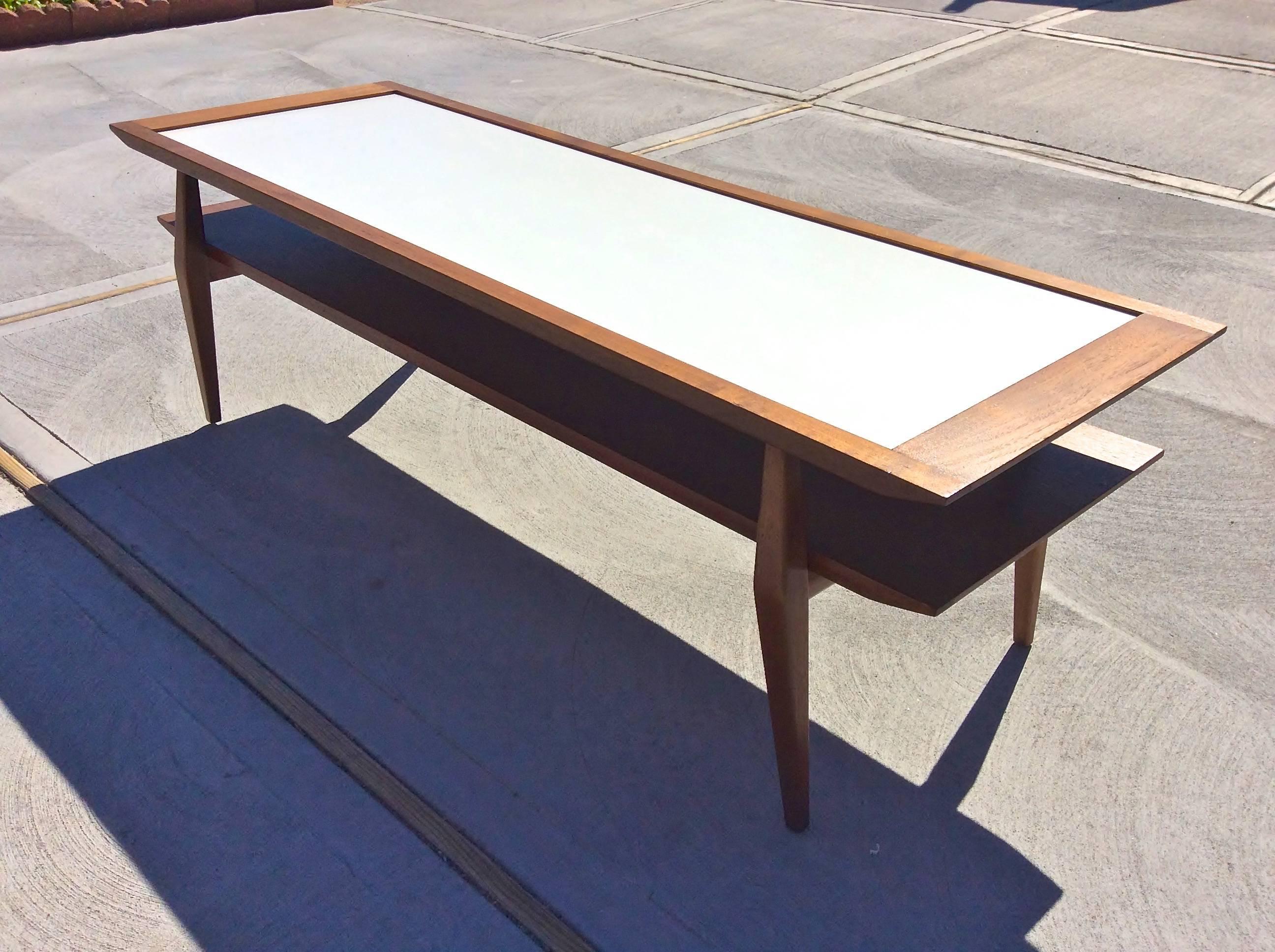 Model 2146 two-tier coffee table in solid walnut with inset white Micarta top designed by Gio Ponti for M. Singer & Sons, produced in Italy by Giordano Chiesa. 
Documented by Gio Ponti Archives. 
Occasionally misattributed to Bertha Schaefer.
Very