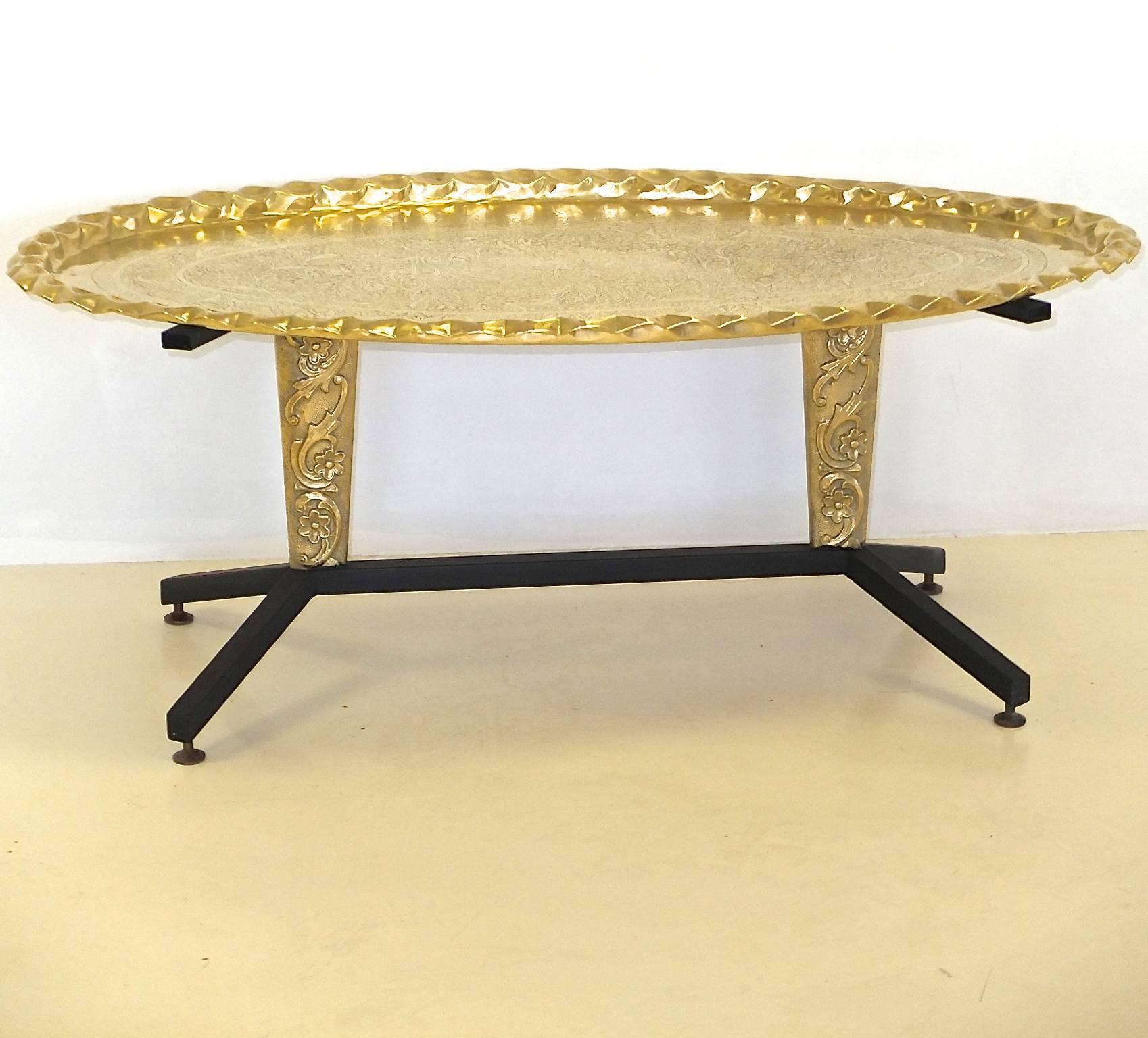 1960s Italian cocktail table with splayed black enameled steel legs and two moulded brass cartouche form pedestals above which are splayed steel supports. 

This table was most likely intended to have a glass or marble top but we have paired it