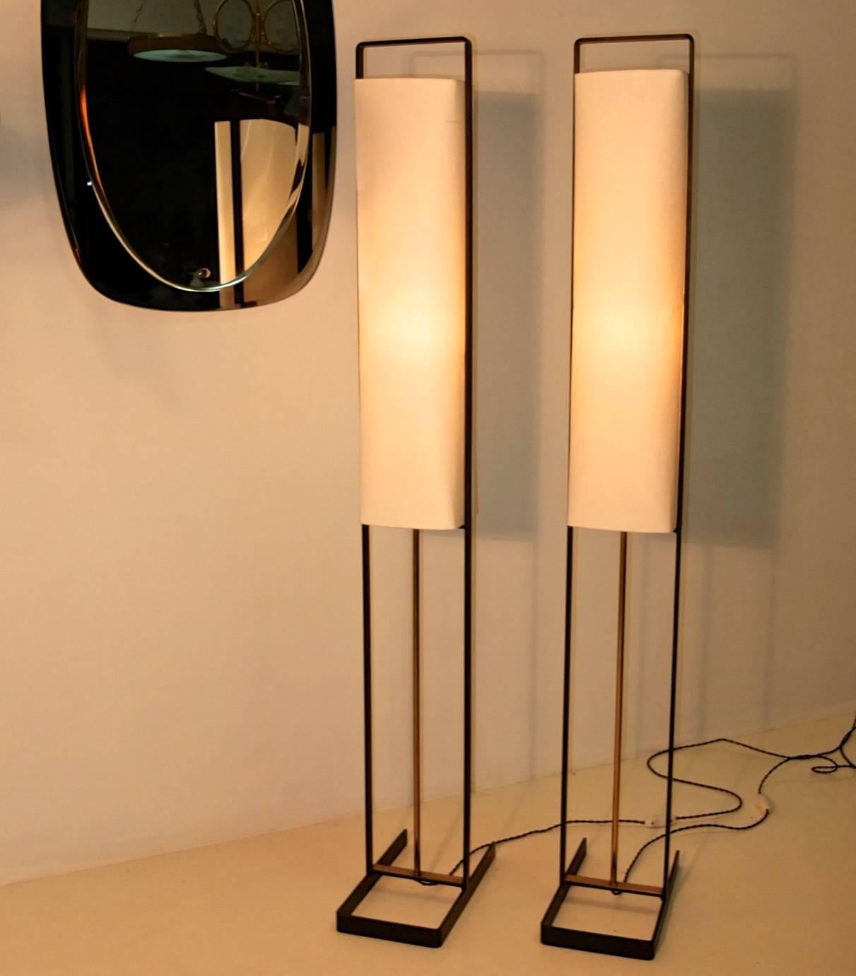 Pair of standing lamps attributed to Jean Boris Lacroix in blackened iron frame of rectilinear form with brass detailing. Lamping is a single 60 watt candelabra size bulb inside a white paper rectangular box shade. Rewired. On/off switch on black