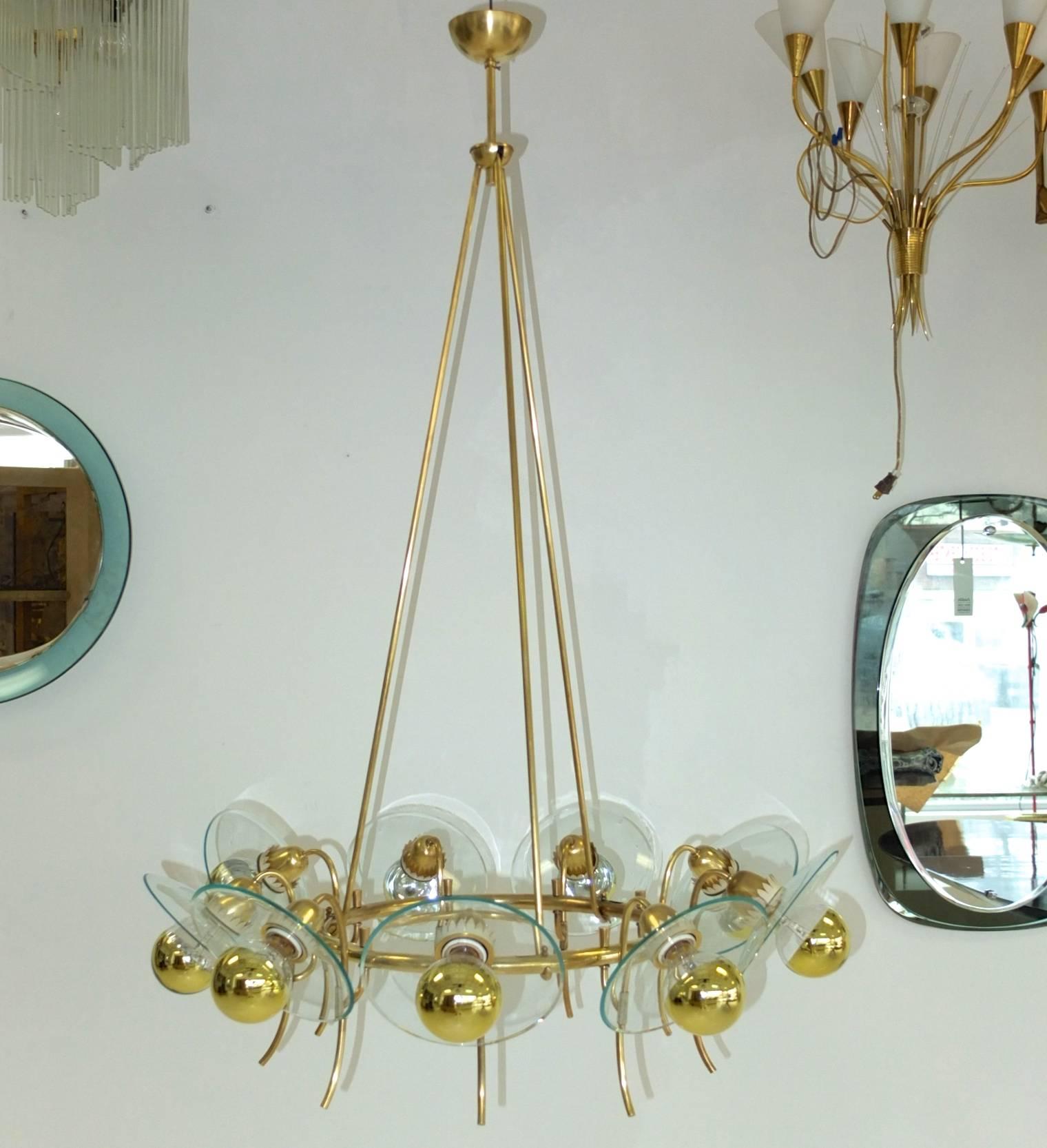 1940s Italian suspended hoop chandelier in the style of Pietro Chiesa for Fontana Arte.

Three brass tubes suspended from a single hub below a half sphere canopy support a 16 inch diameter round brass tube attached to which nine curved brass tulip