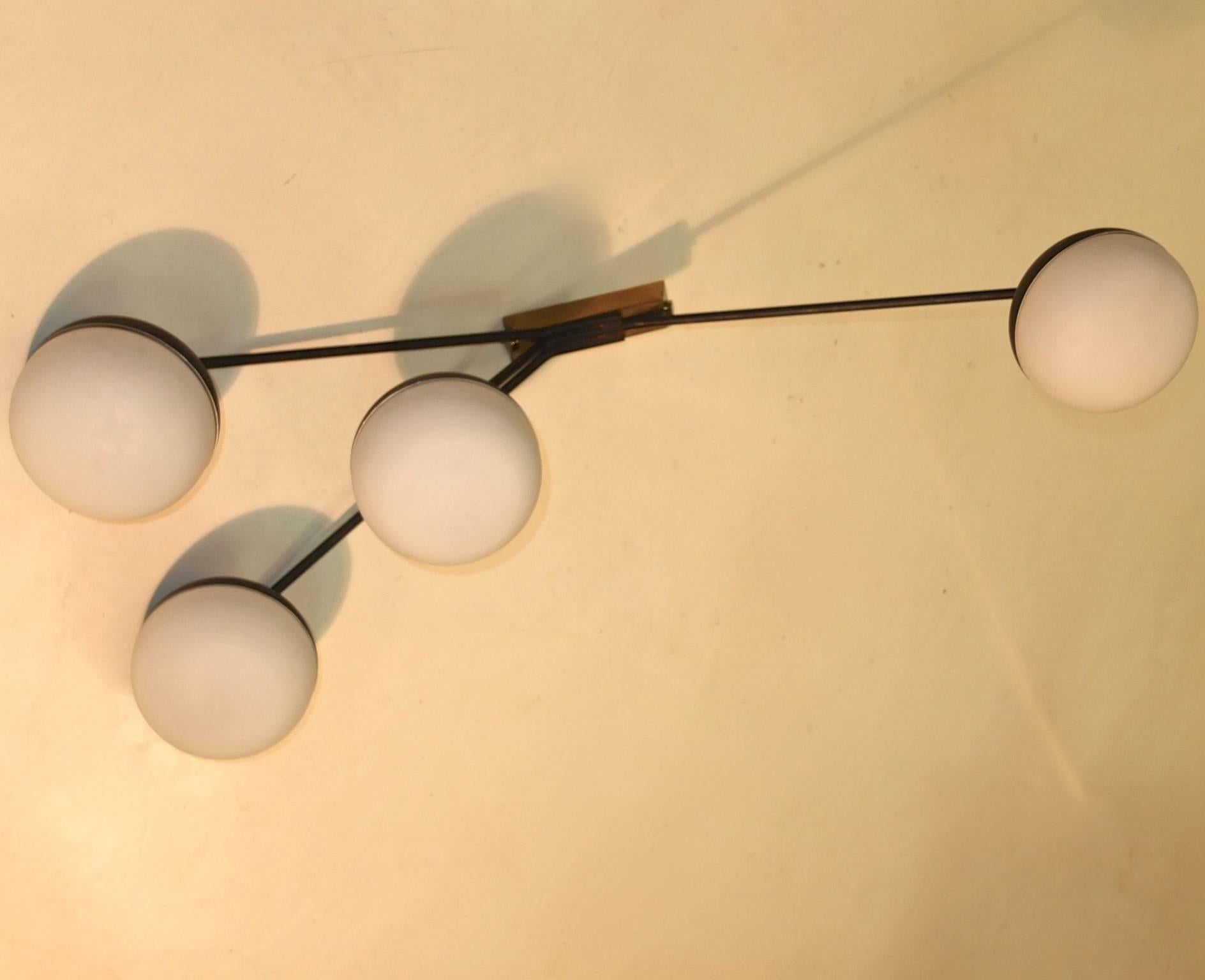 Maison Arlus seems to be tipping its hat to Angelo Lelii of Arredoluce but this fixture is all French. Designed, circa 1953 with a tapered brass box back or ceiling plate for versatile mounting options. Four elongated enameled steel arms terminating