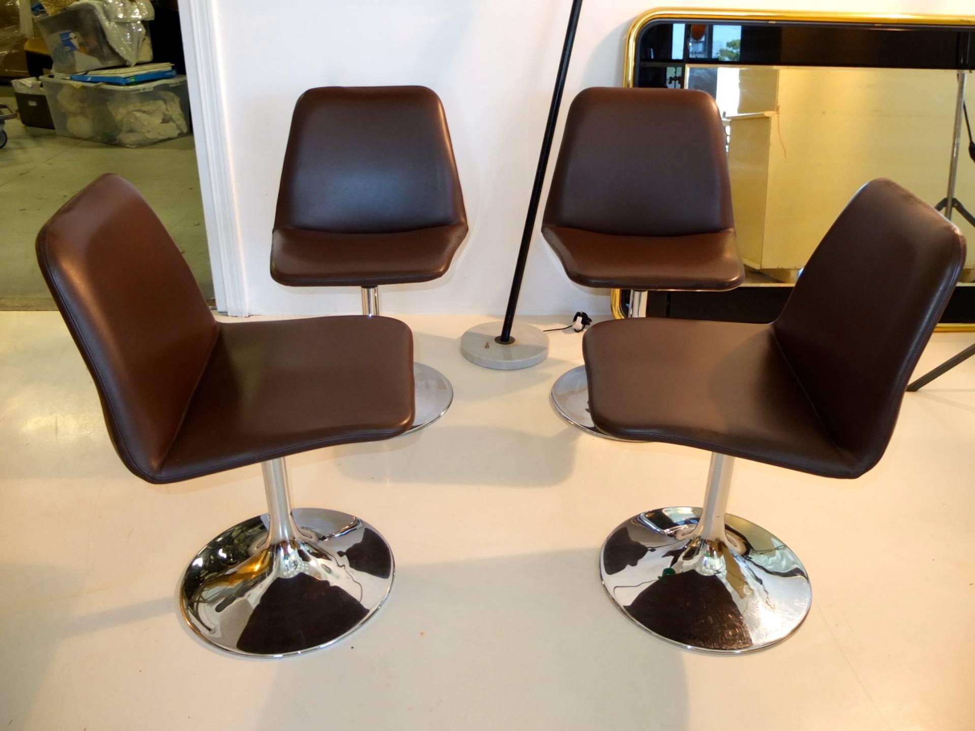 Set of four early production Vinga swivel chairs by Börje Johanson upholstered in chocolate brown faux leather on chromed steel tulip form pedestal bases.

These chairs were retailed by Ben & Jane Thompson of Design Research in Cambridge, MA in