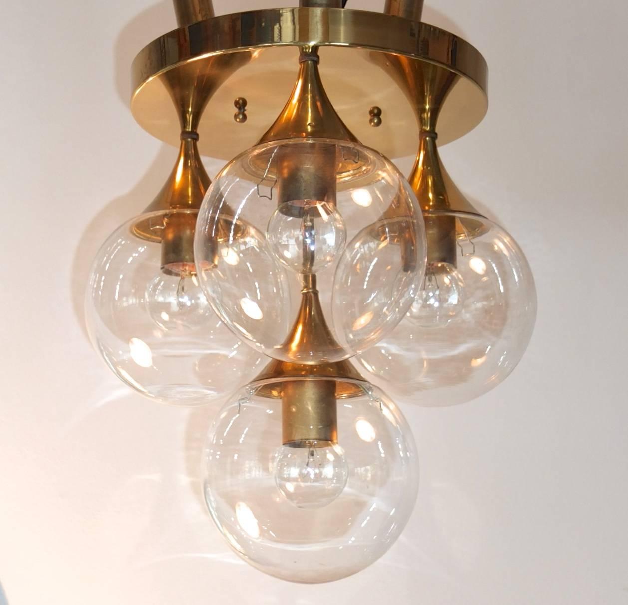 Groovy 1960s ceiling mounted light fixture by Lightolier with four clear glass globe lights on brass horn stems. Four standard Edison screw sockets for bulbs up to 75 watts each. Very good condition. Nice light patina to the brass. Globes are easy
