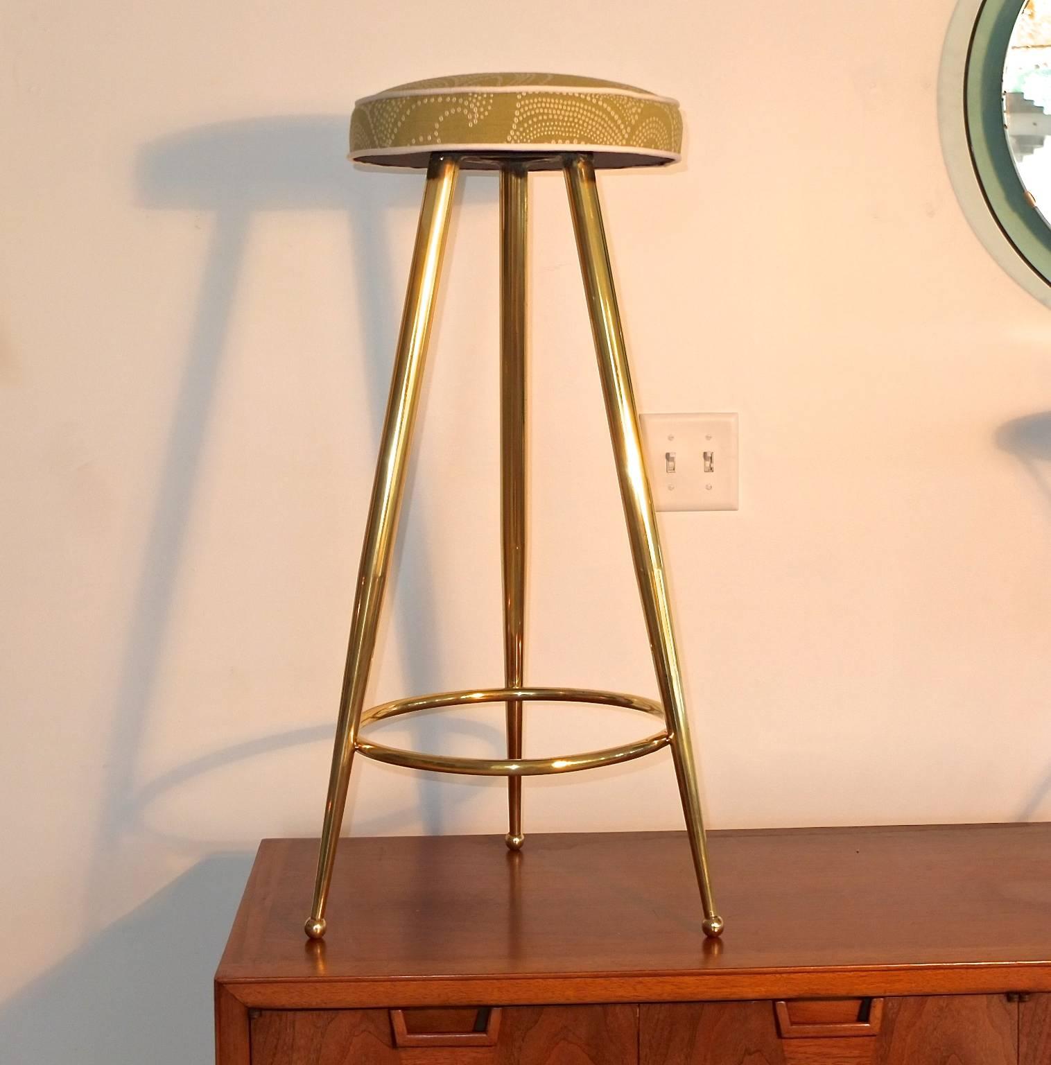 Classic original 1950s Italian Mid-Century Modern bar stools constructed of three solid brass tapered legs on brass ball feet, braced by a solid brass ring footrest and at the top a triangular steel bracket attached to which is the round box-edge