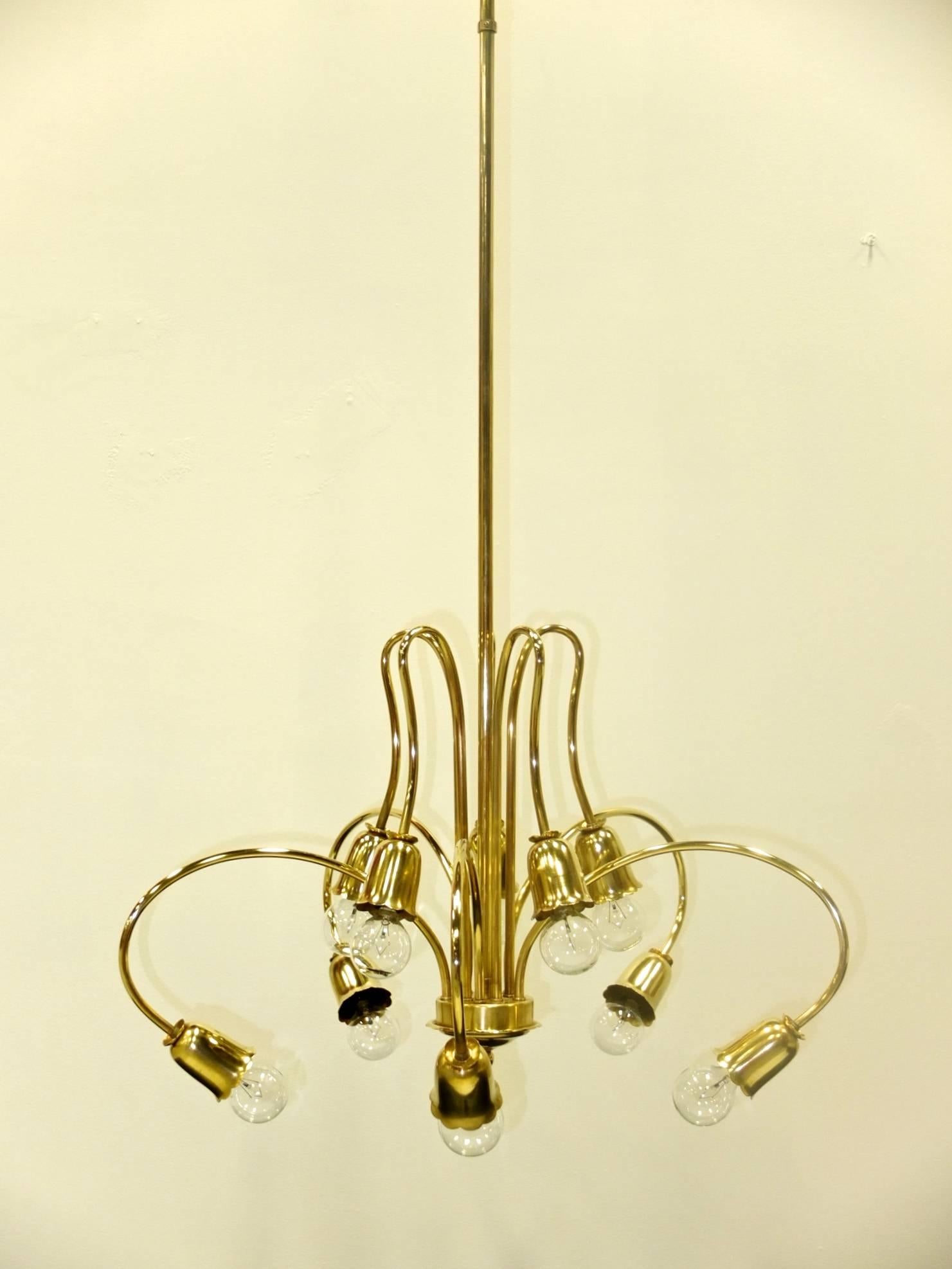 1950s Italian chandelier with ten extravagantly bent tubular brass arms terminating in scalloped edge bell form socket cups and daintily scalloped collars.

Rewired. Each socket takes a single candelabra size bulb up to 60 watts each.

Stem can
