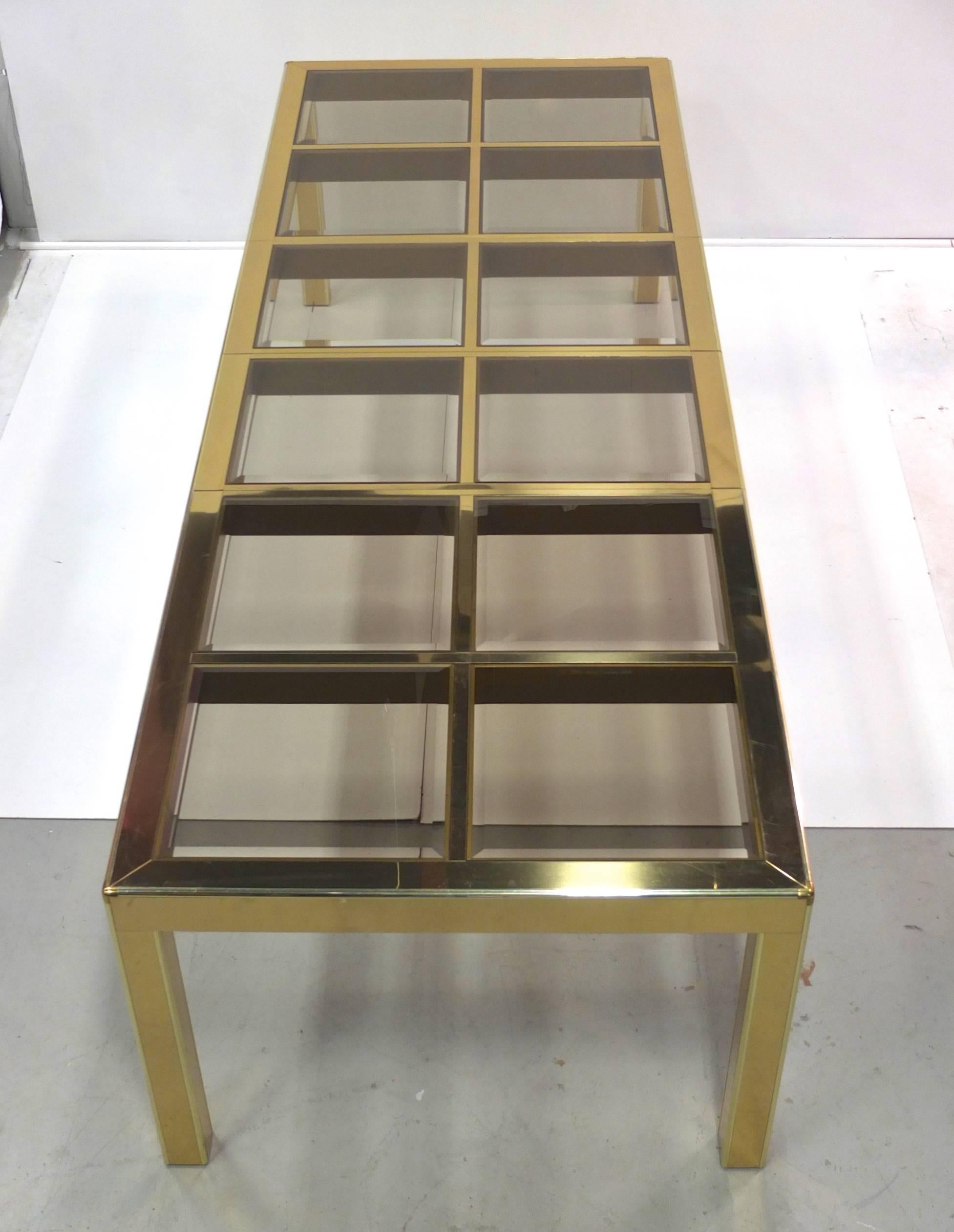 Vintage 1970s Mastercraft extendible dining table clad in mirror polished brass with twelve transparent smoked beveled glass squares inset into the top. Including both 19.5