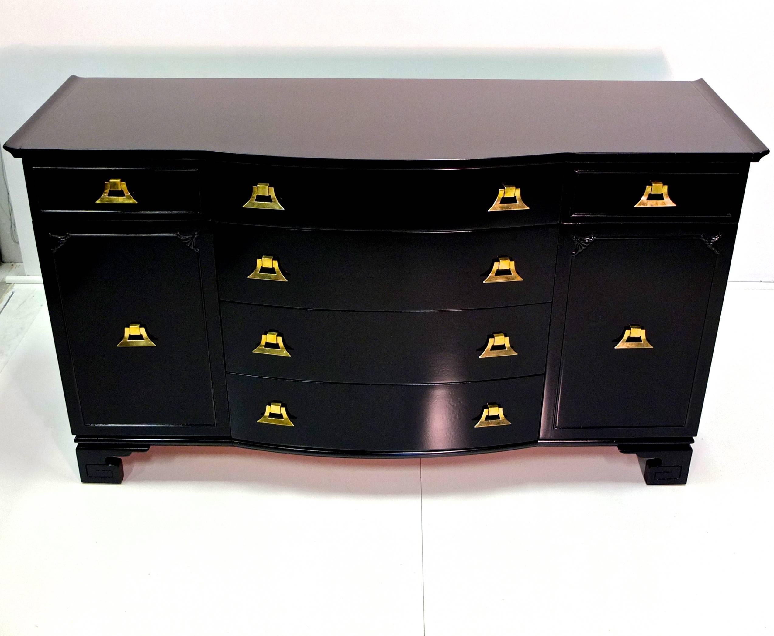 Pagoda form black and brass sideboard buffet in the style of James Mont with ming shaped feet and Asian motif detailing from the Exotic Modernist movement of the late 1940s-early 1950s, including distinctive solid brass bell form decorative pulls.