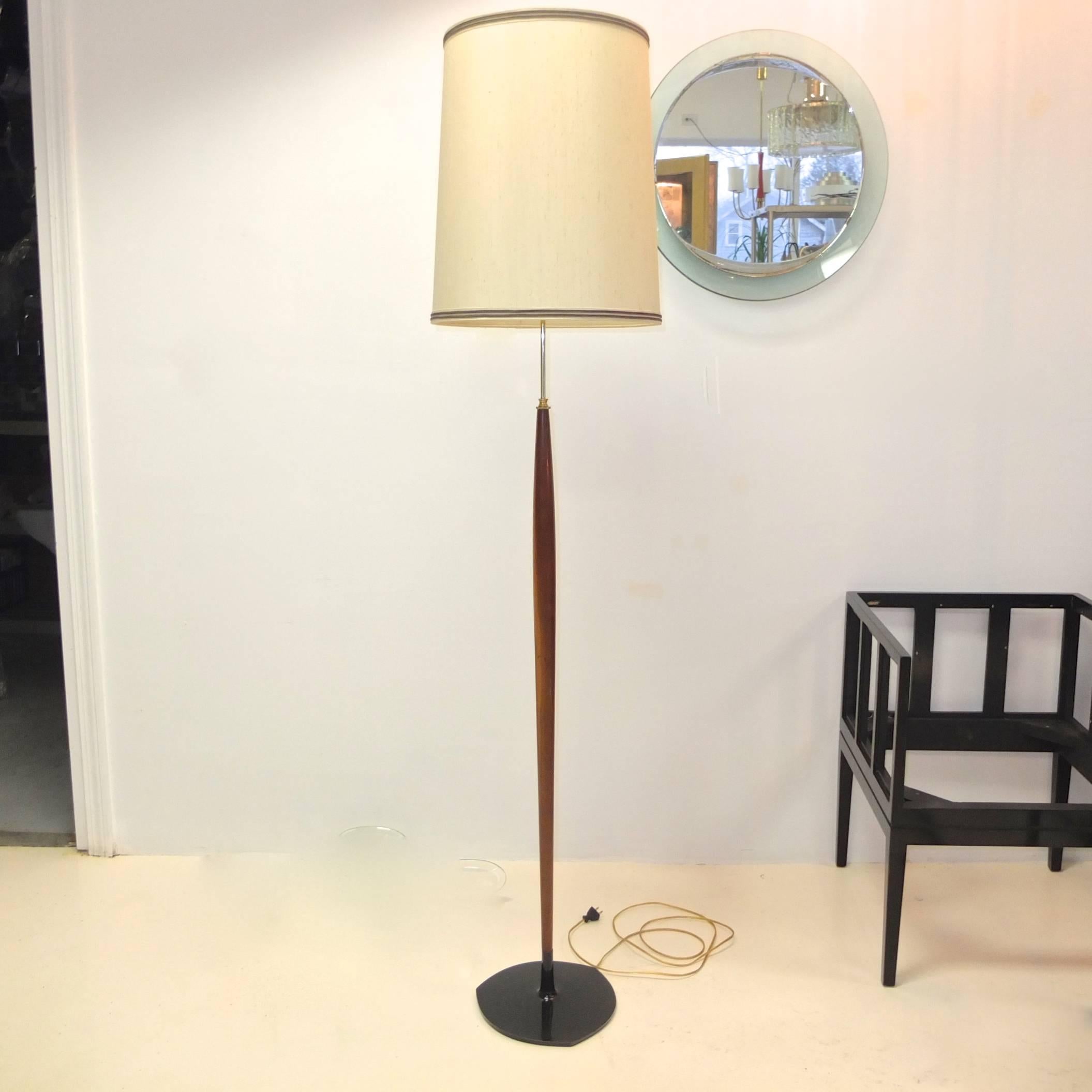 Scandinavian floor lamp from the 1960s of unusual form with sculptural tapered teak which has been turned in such a way as to taper from the base at a Fine point then flare out to form a bulbous belly, like a snake digesting its prey, finally