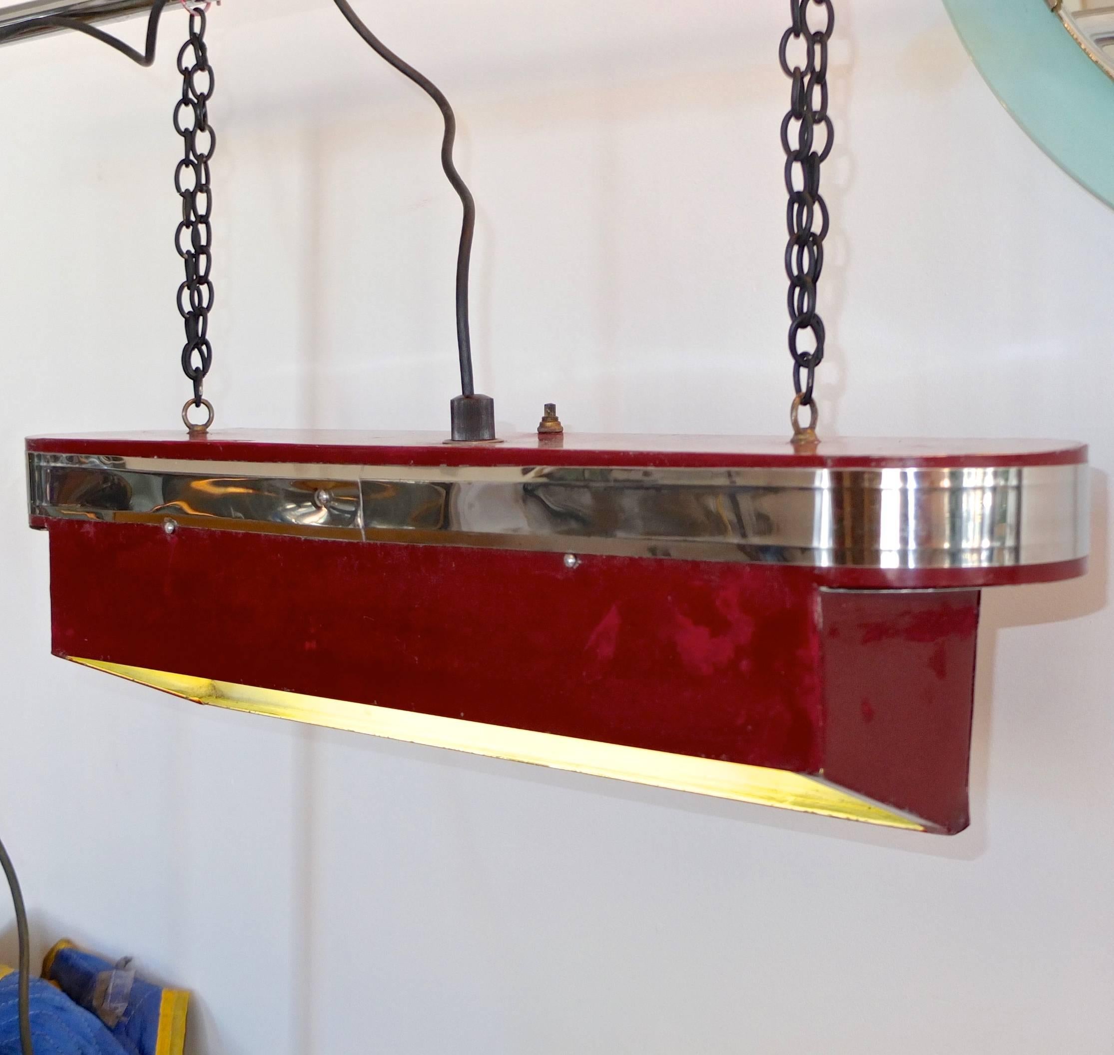 Streamline Art Deco horizontal hanging light with 17 inch fluorescent tube light. Stylish machine age oblong top reminiscent of a transatlantic ocean liner with chrome banding above wedge form steel box painted burgundy red. On or off switch on top